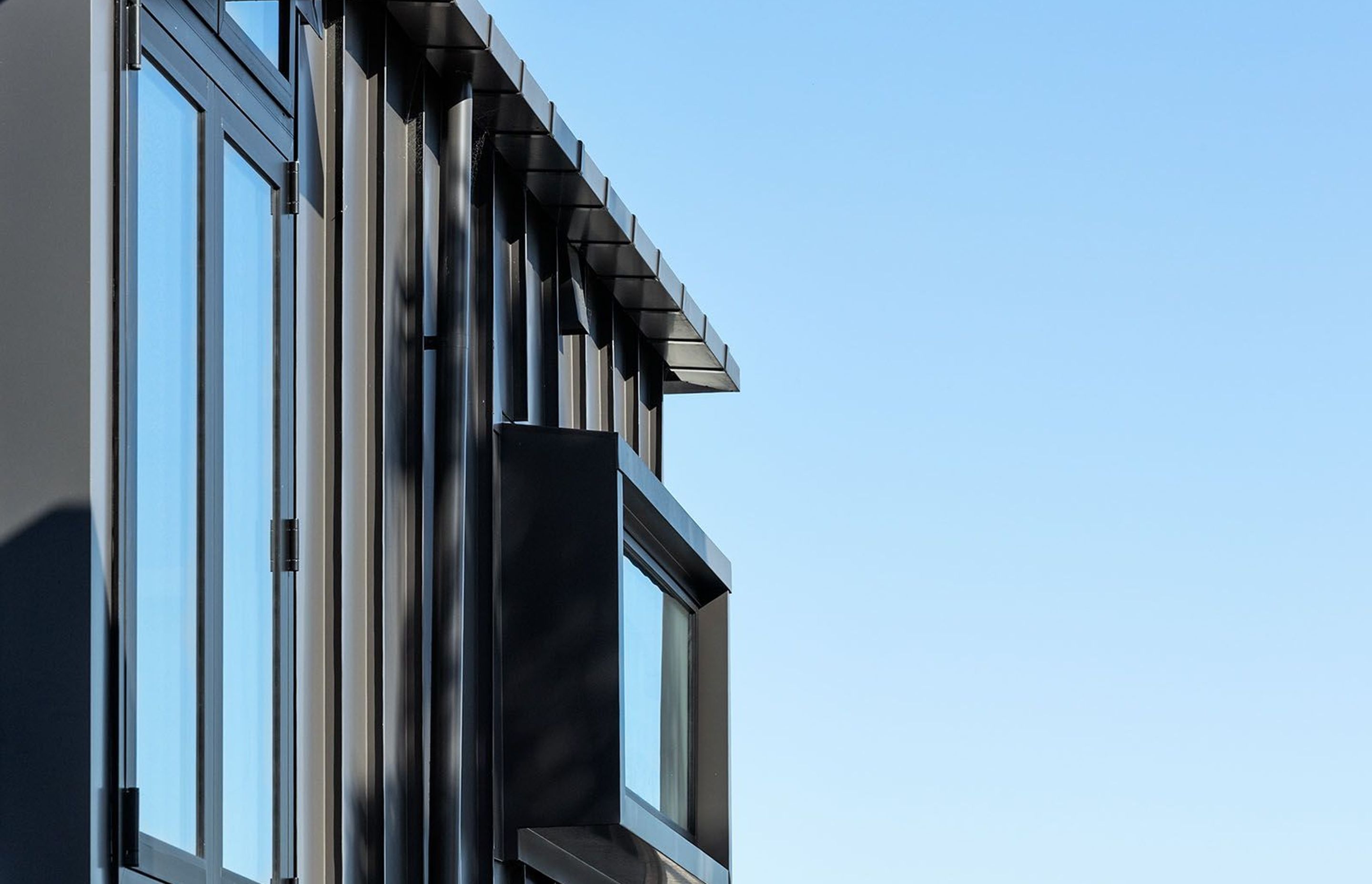 Standing seam aluminium cladding is used on the exterior of the third storey.