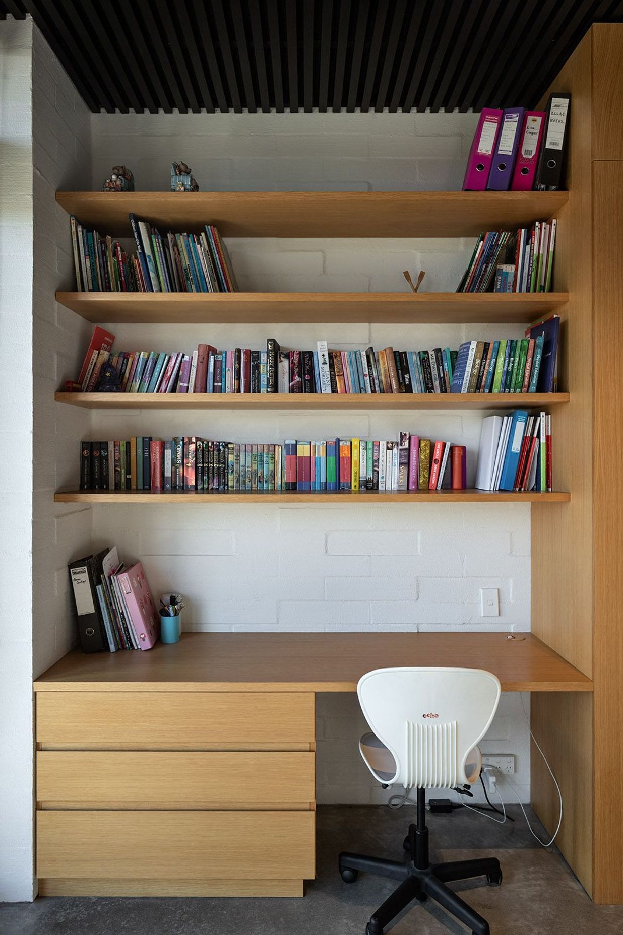 A dark cedar ceiling complements the lighter cabinetry and concrete block walls.