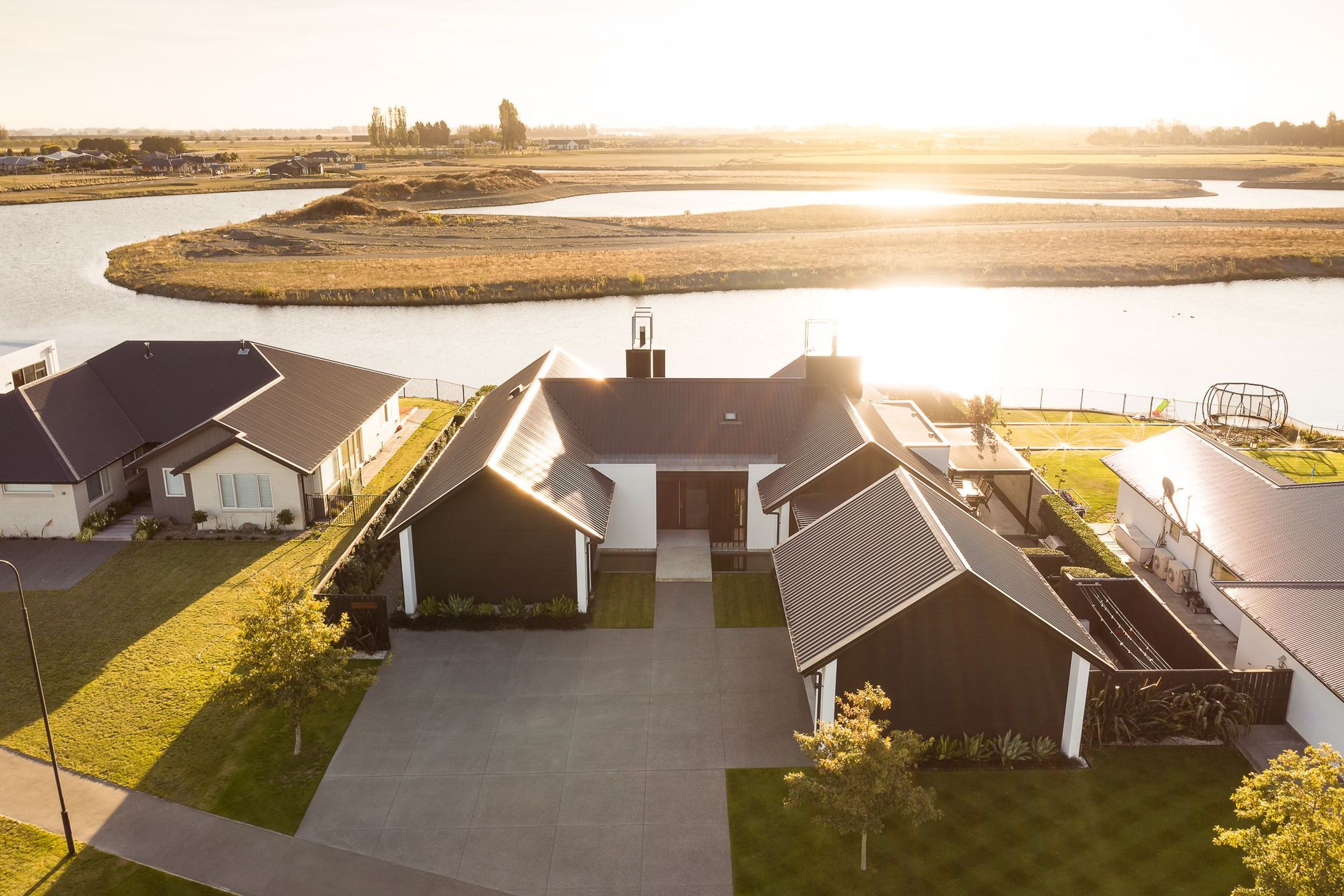 Programmatically, the house reads as two linked pavilions in an elongated, asymmetrical H shape with bedrooms in one pavilion and living in the other.