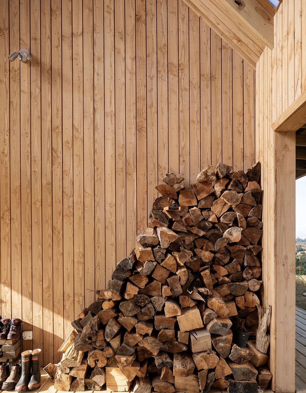 The firewood stack is kept dry and handy to reach.