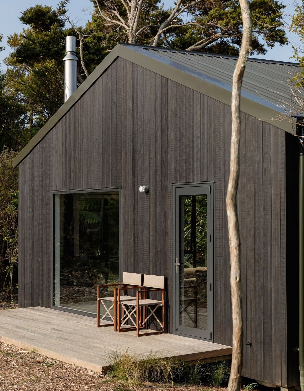 The front deck is accessed by way of a side door, rather than from the living area where a fixed window creates the main feature.