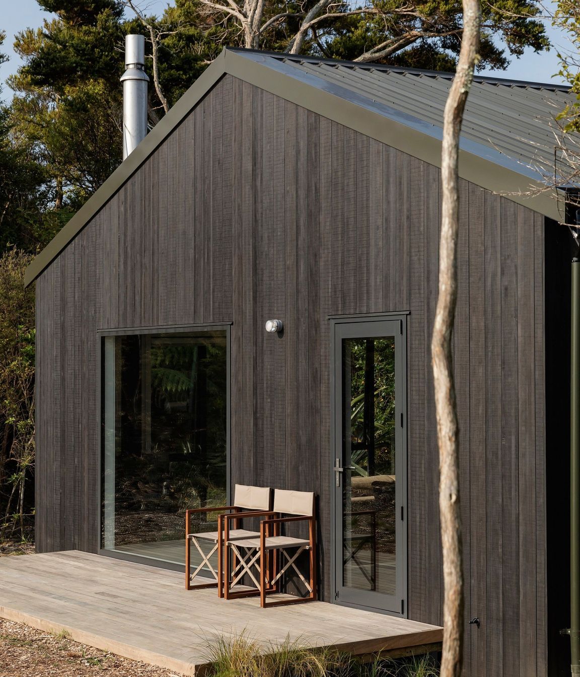The front deck is accessed by way of a side door, rather than from the living area where a fixed window creates the main feature.