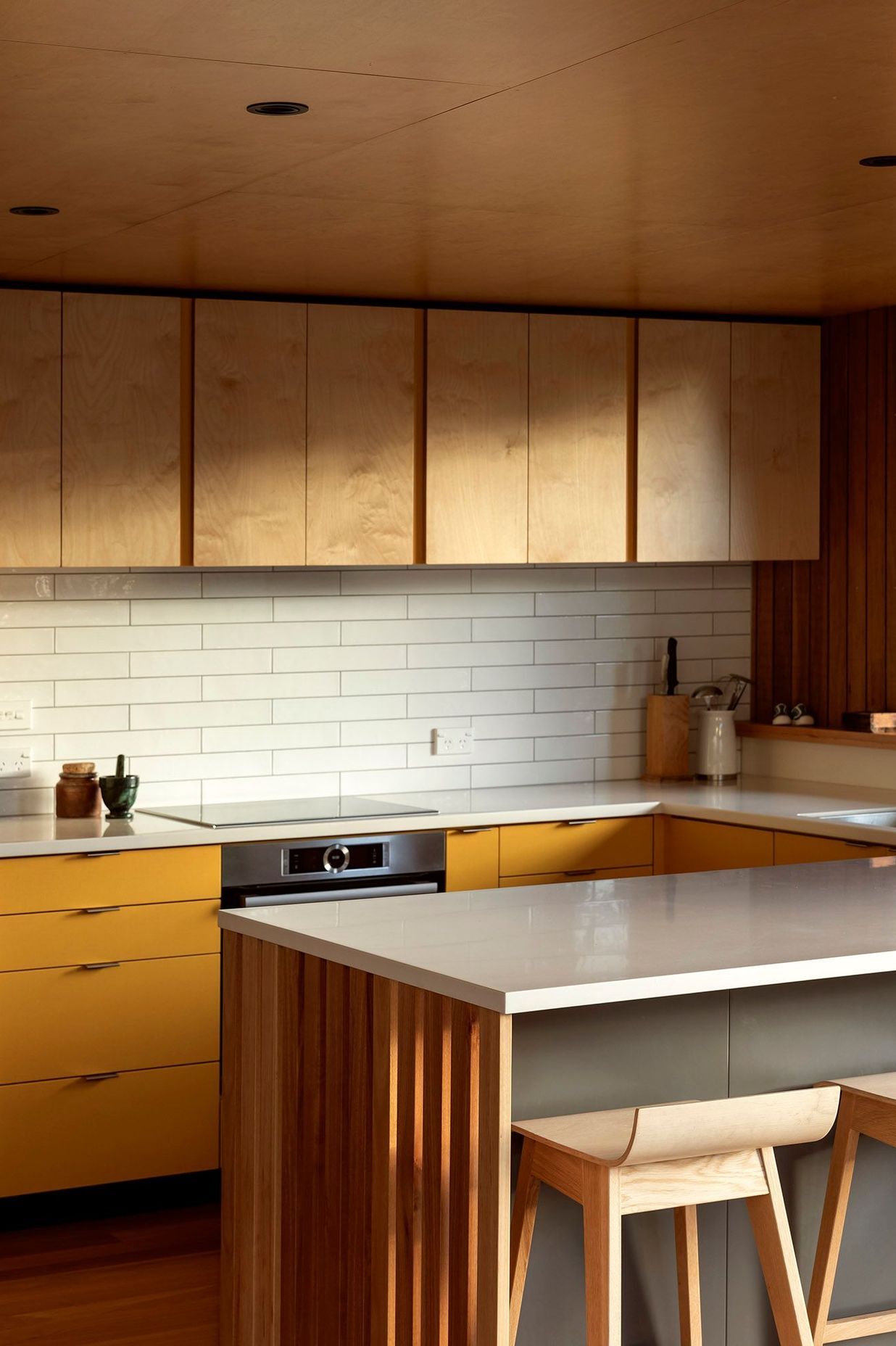 Birch ply cabinetry is used in the kitchen with accents of yellow laminate and Australian hardwood flooring.