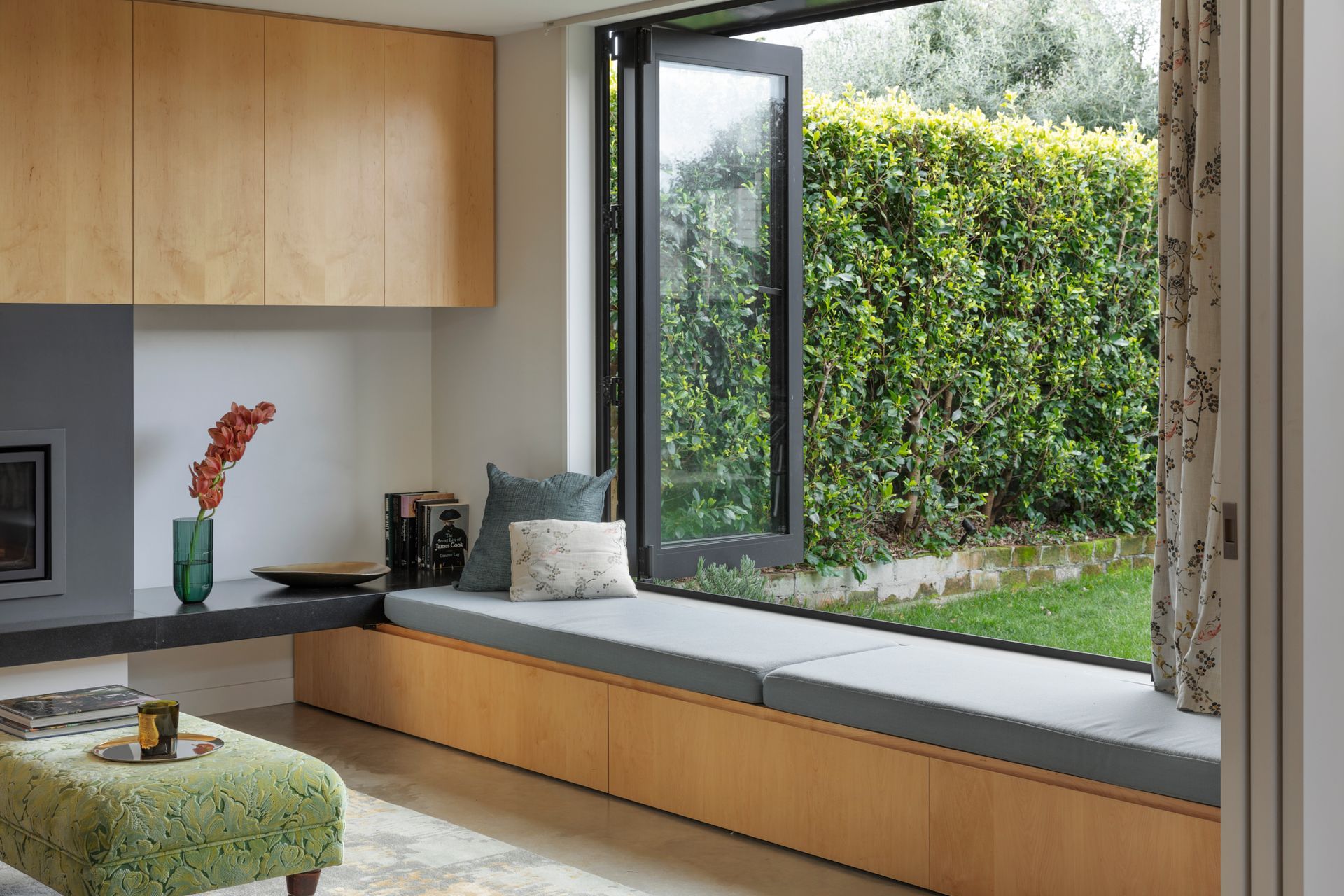 The window seat under a bi-folding door provides a quiet space overlooking the garden.