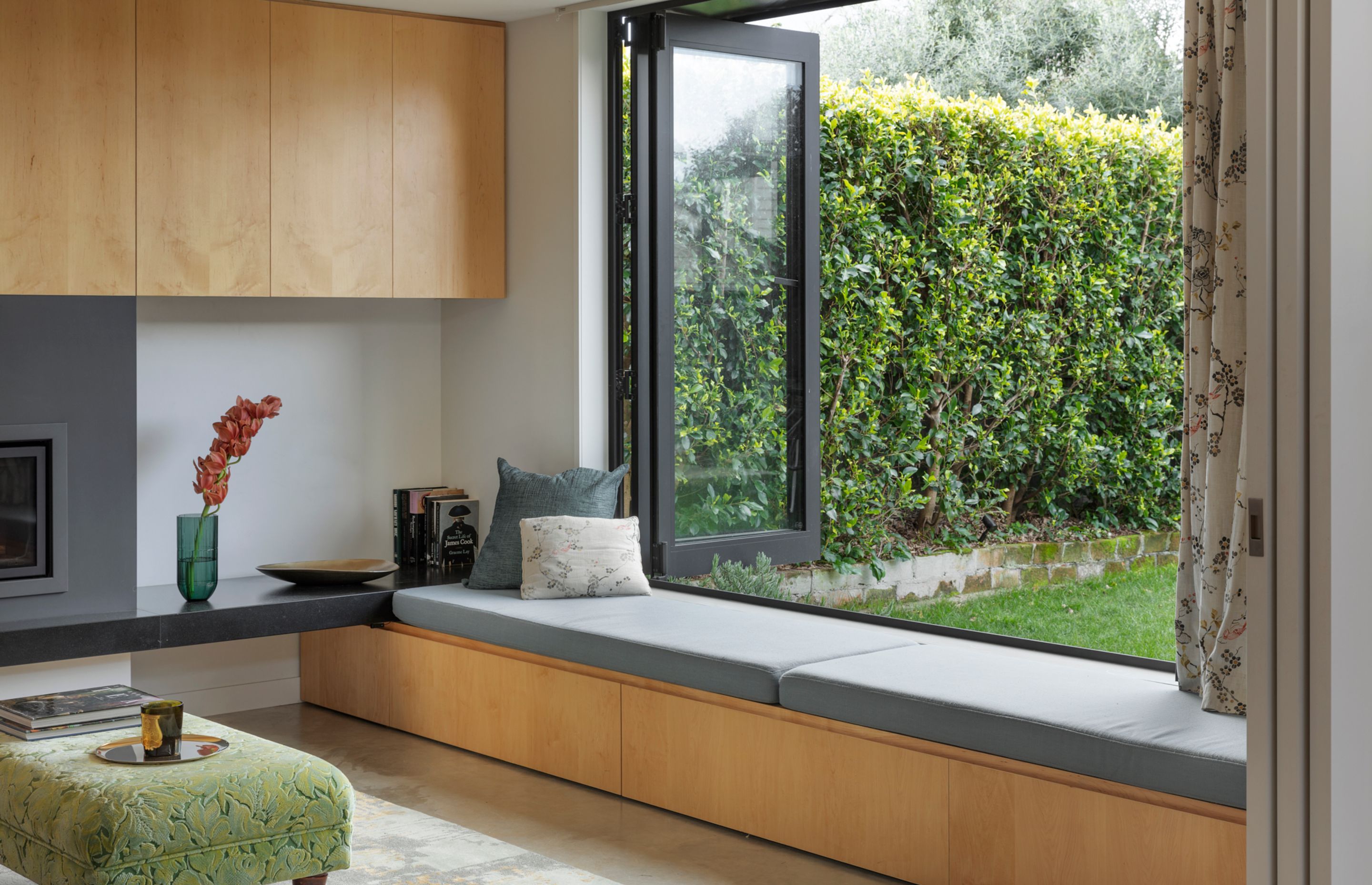 The window seat under a bi-folding door provides a quiet space overlooking the garden.