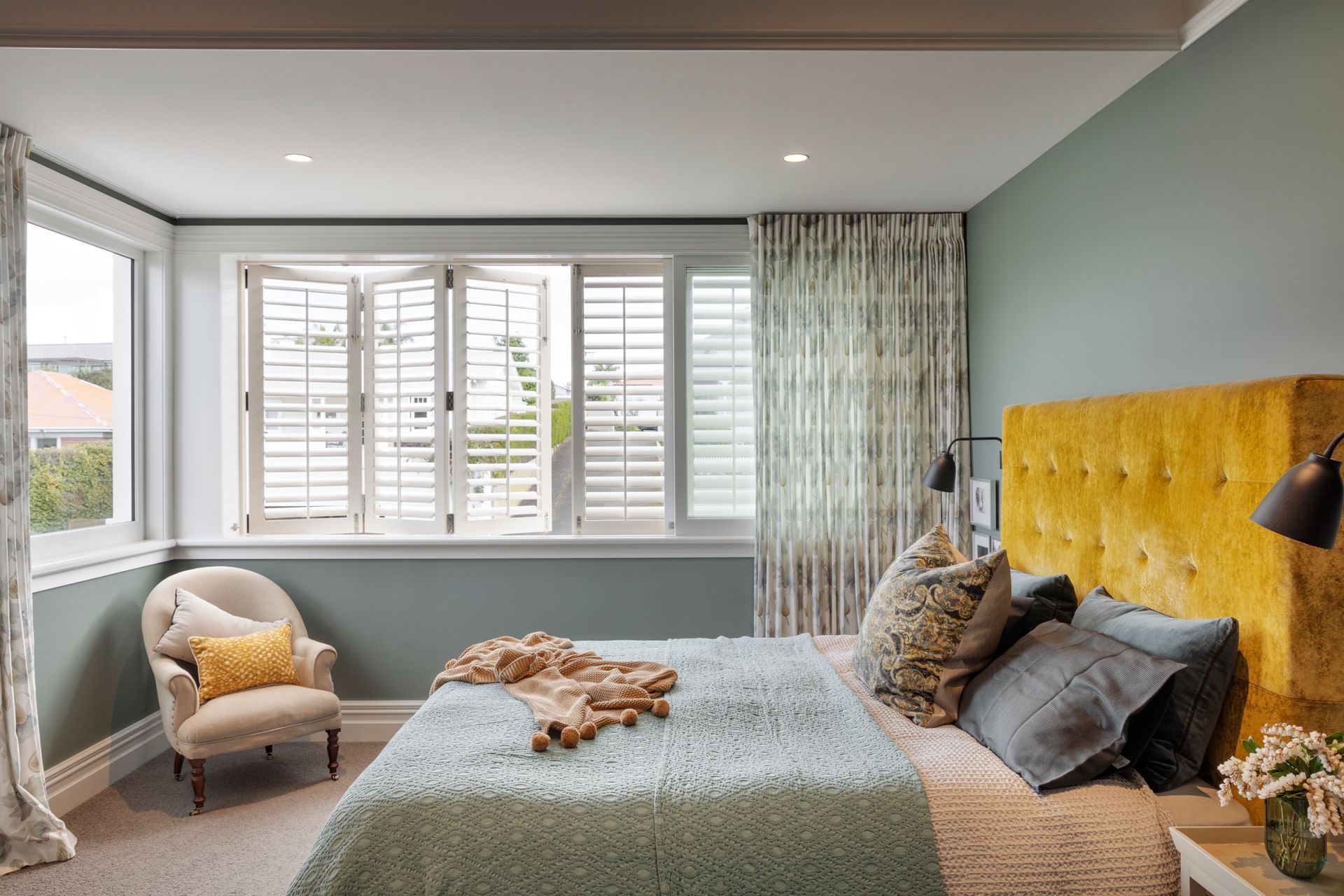 The master bedroom at the front of the house has shuttered windows and curtains for added privacy.