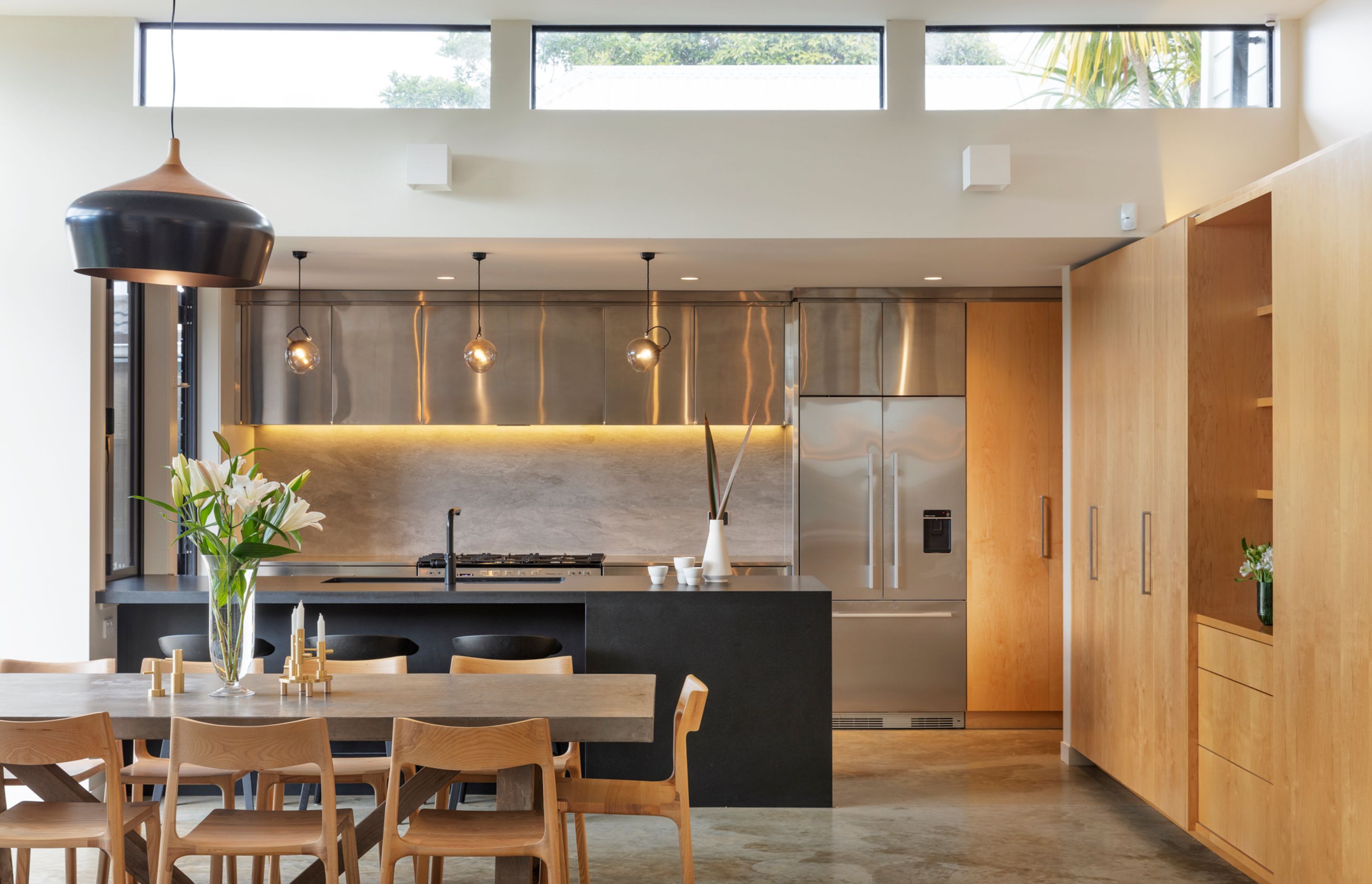 The kitchen ceiling is lower than the ceiling in the dining area, which features high clerestory windows that draws light into the space.