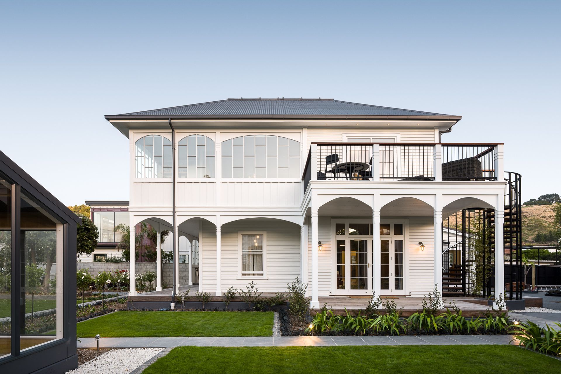 Esplanade House has an upstairs outdoor living area outlooking the sea across the road and a wraparound verandah with multiple arches.