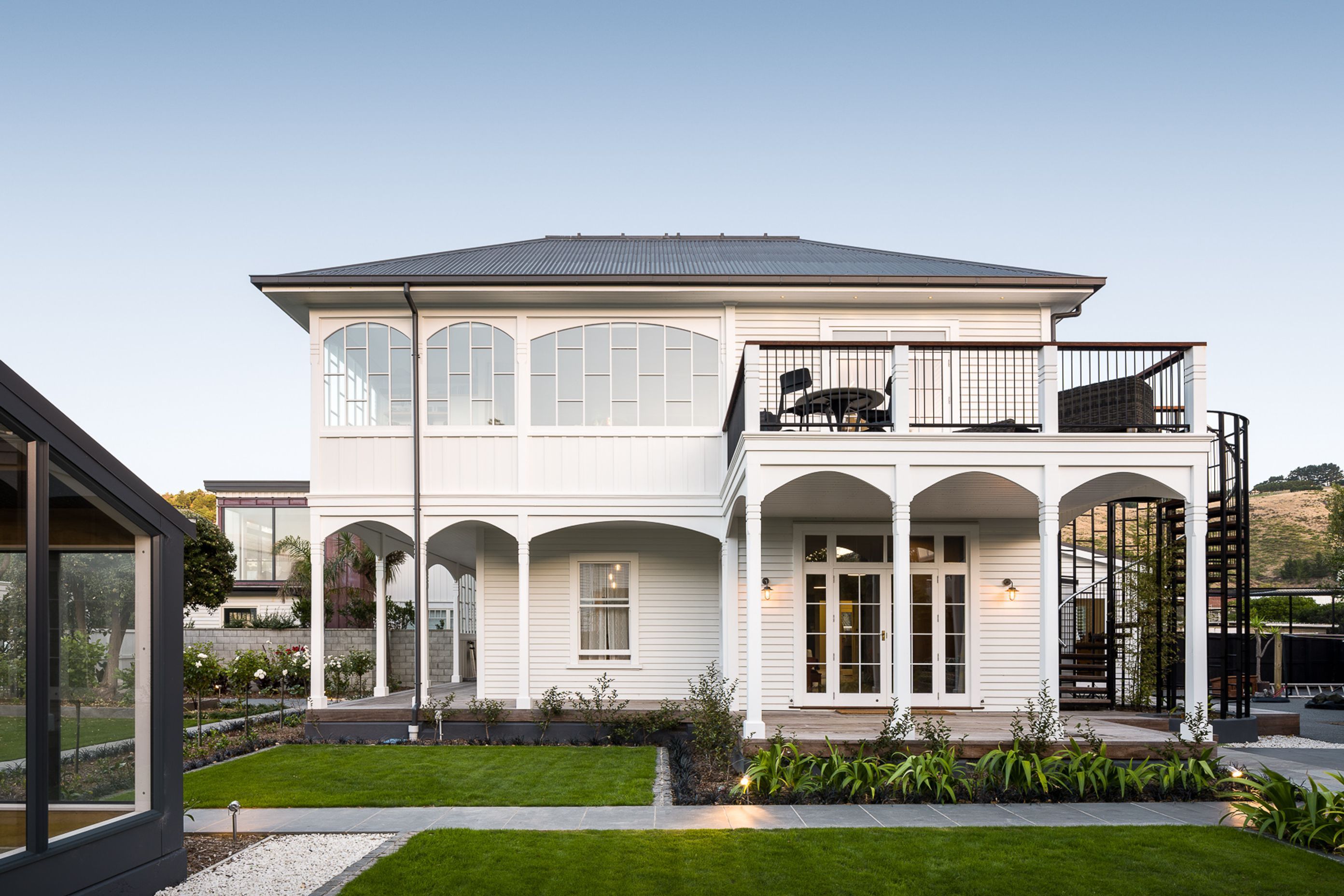 Esplanade House has an upstairs outdoor living area outlooking the sea across the road and a wraparound verandah with multiple arches.