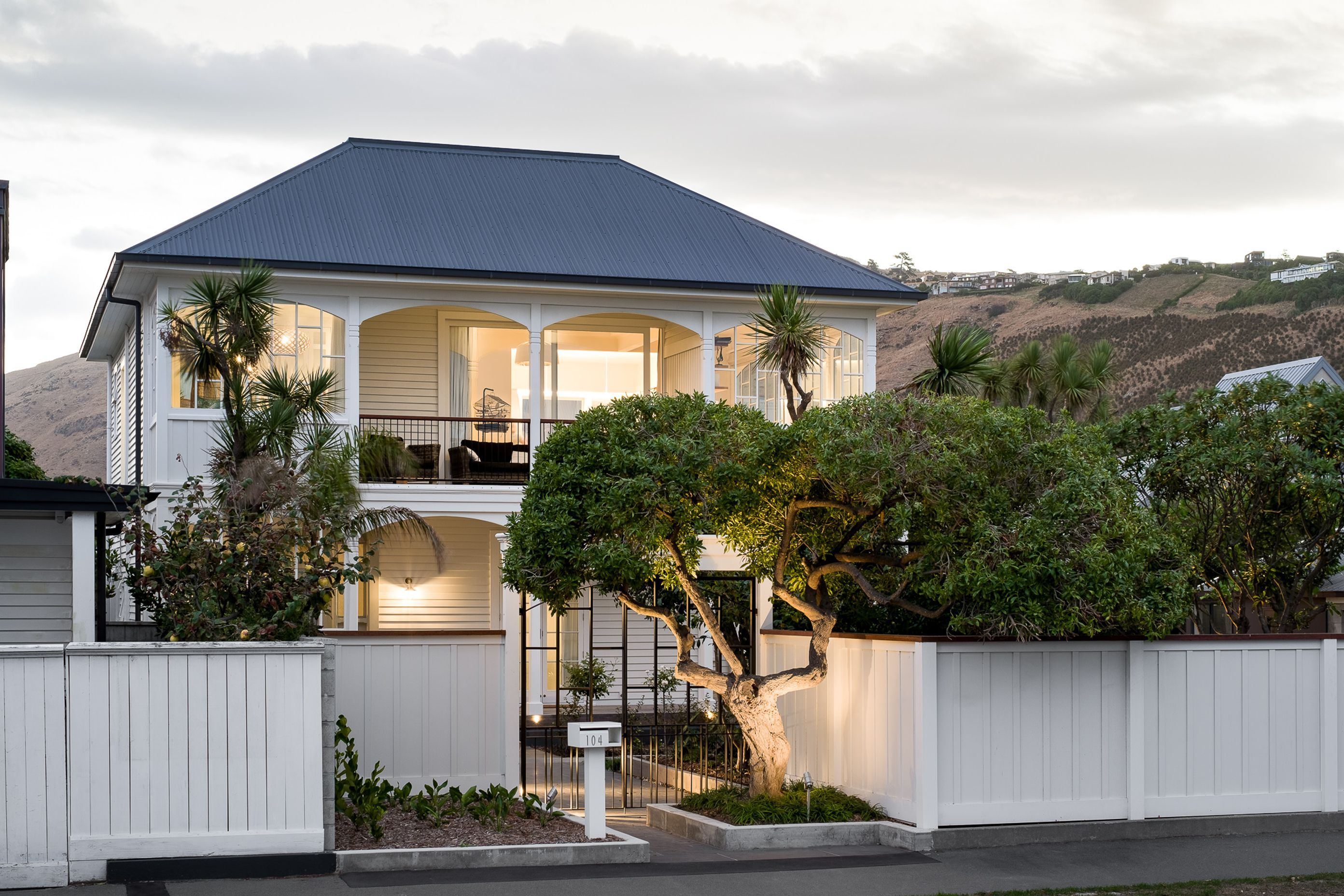 The street view of the house at dusk is an impressive site. The unusual front entrance has been designed around an established tree.