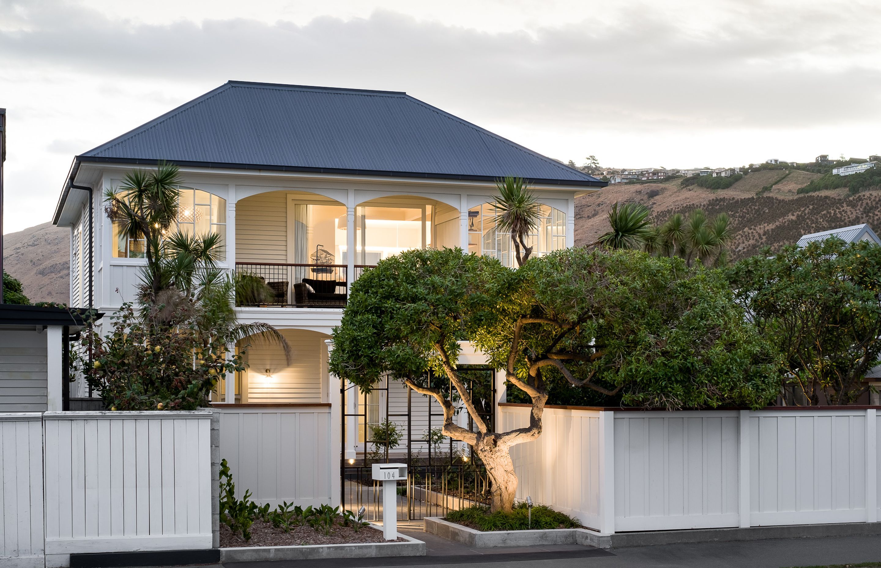 The street view of the house at dusk is an impressive site. The unusual front entrance has been designed around an established tree.