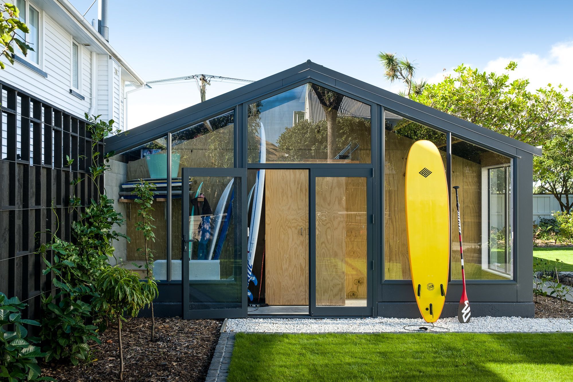 A new extension to the garage is like a 'display cabinet' of the family's lifestyle, providing an easy-access home for their surfboards and paddleboards.