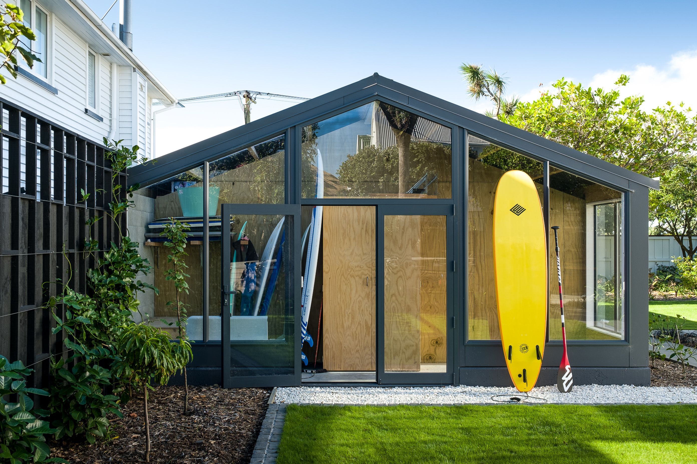 A new extension to the garage is like a 'display cabinet' of the family's lifestyle, providing an easy-access home for their surfboards and paddleboards.