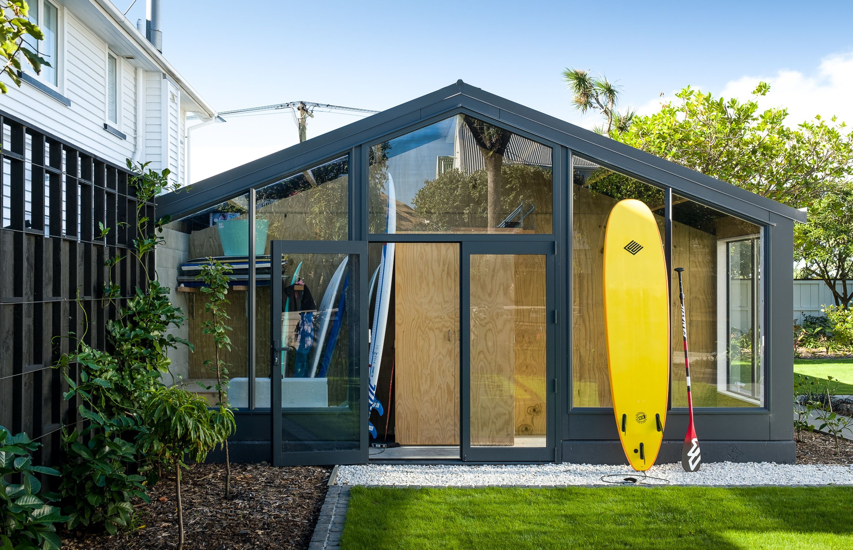 A new extension to the garage is like a 'display cabinet' of the family's lifestyle, providing an easy-access home for their surfboards and paddleboards.