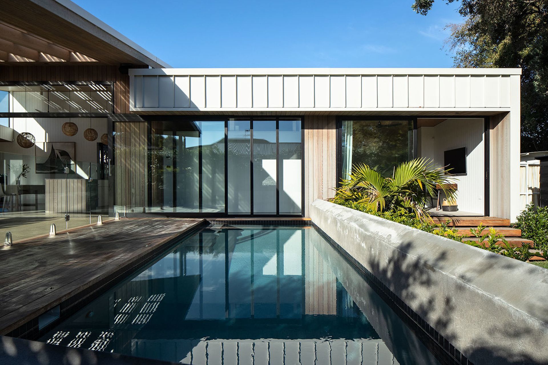 The bedrooms are recessed under the eaves to help control the entry of sunlight, while reflected watery patterns are cast onto the interior surfaces from the pool.