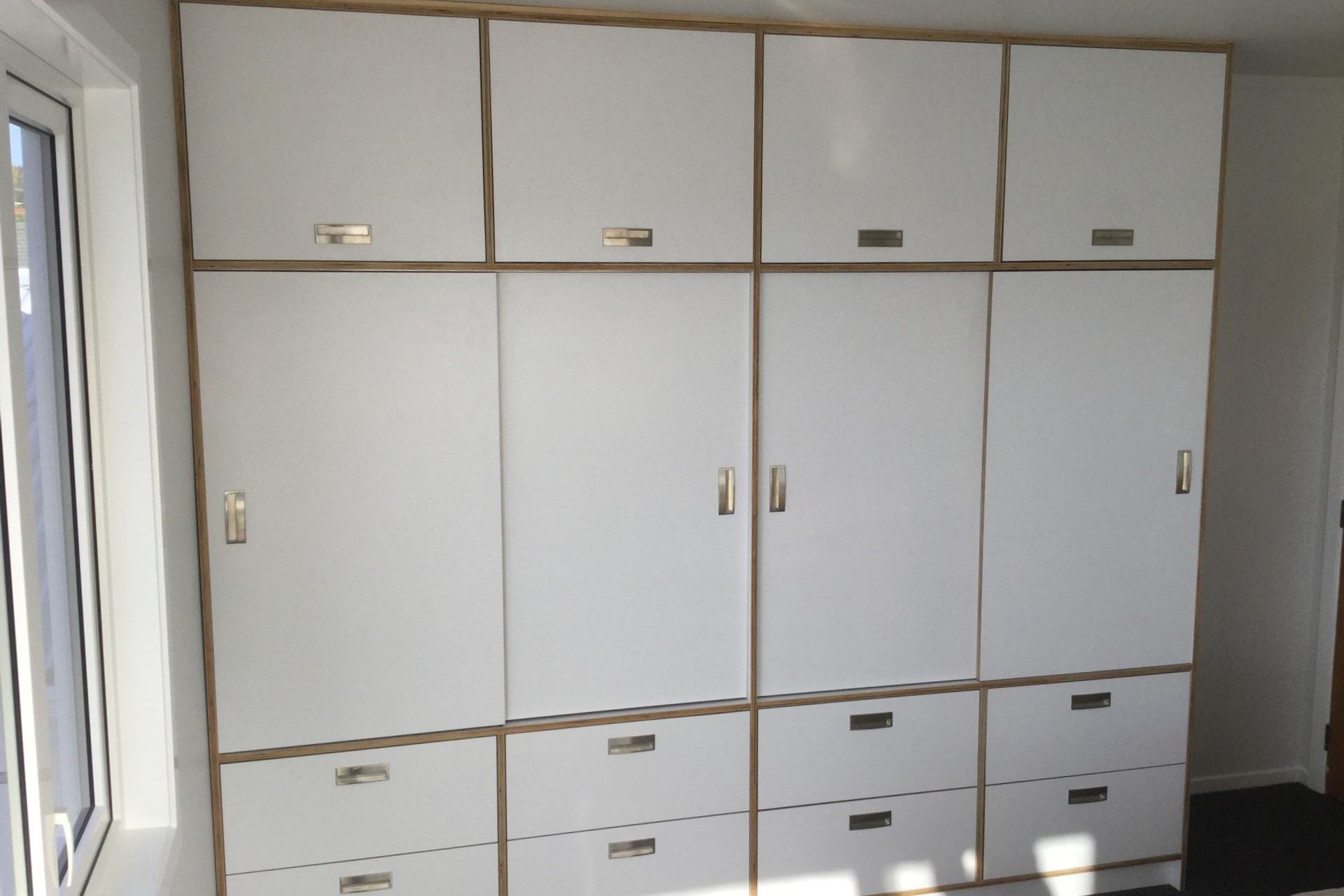 Custom-built wardrobe amd drawers made from HPL italia on Birch ply from Plymasters. Recessed Brushed Nickel Arezzo Handles by Archant. Other door hardware by Hafele.