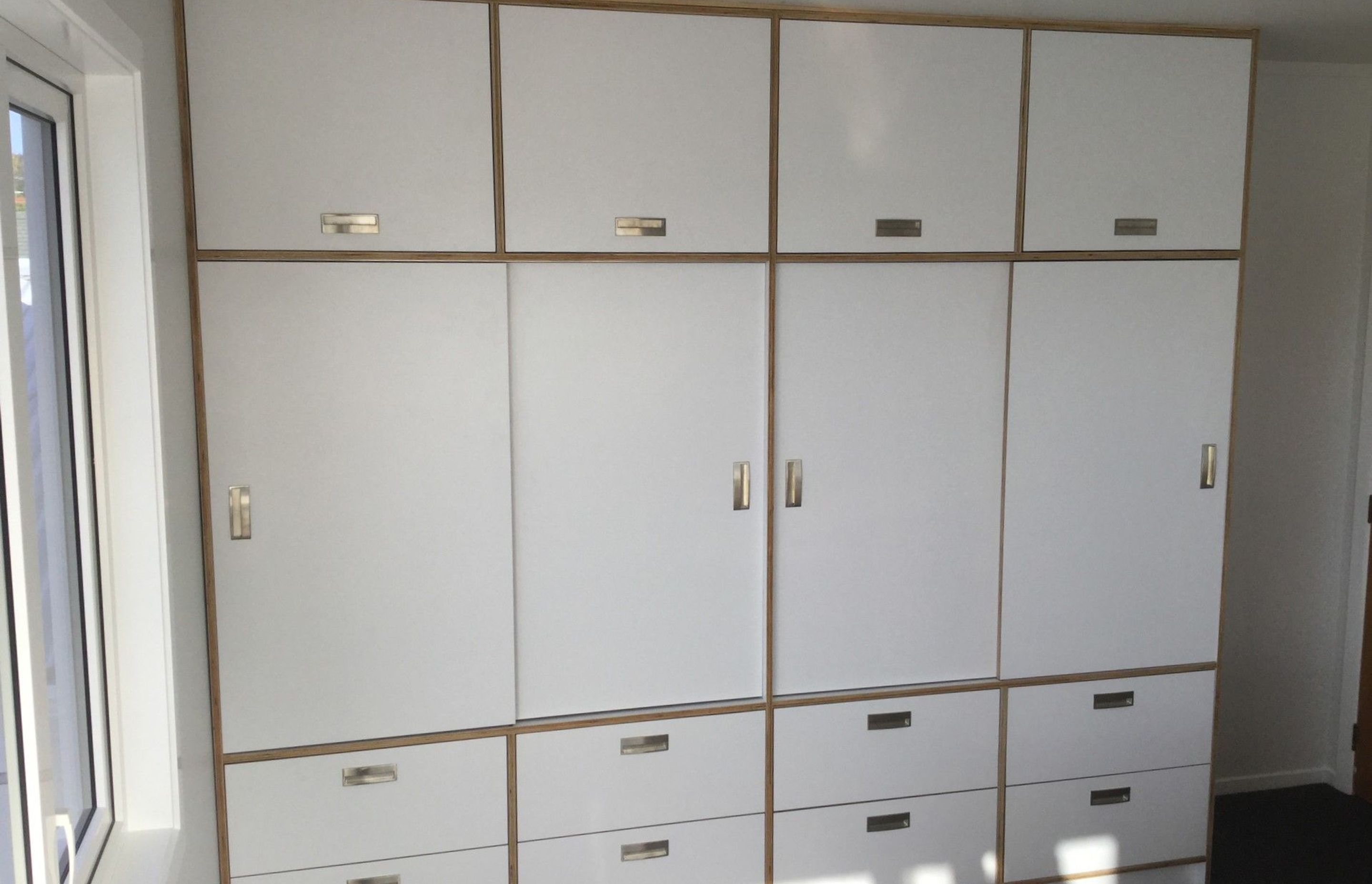 Custom-built wardrobe amd drawers made from HPL italia on Birch ply from Plymasters. Recessed Brushed Nickel Arezzo Handles by Archant. Other door hardware by Hafele.