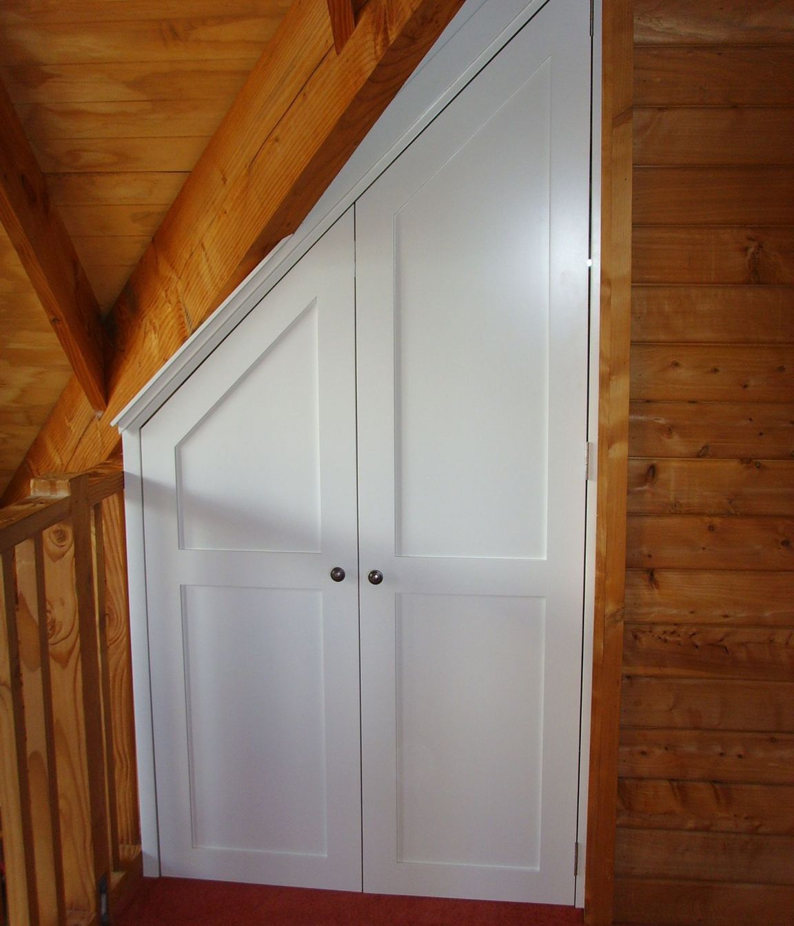 Storage cupboard in-built under roof eaves.