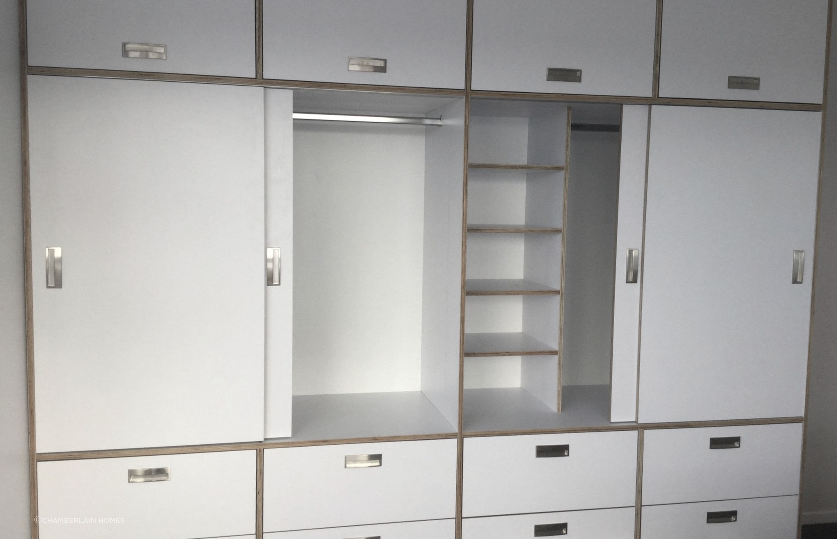 Custom-built wardrobe amd drawers made from HPL italia on Birch ply from Plymasters. Recessed Brushed Nickel Arezzo Handles by Archant. Other door hardware by Hafele.