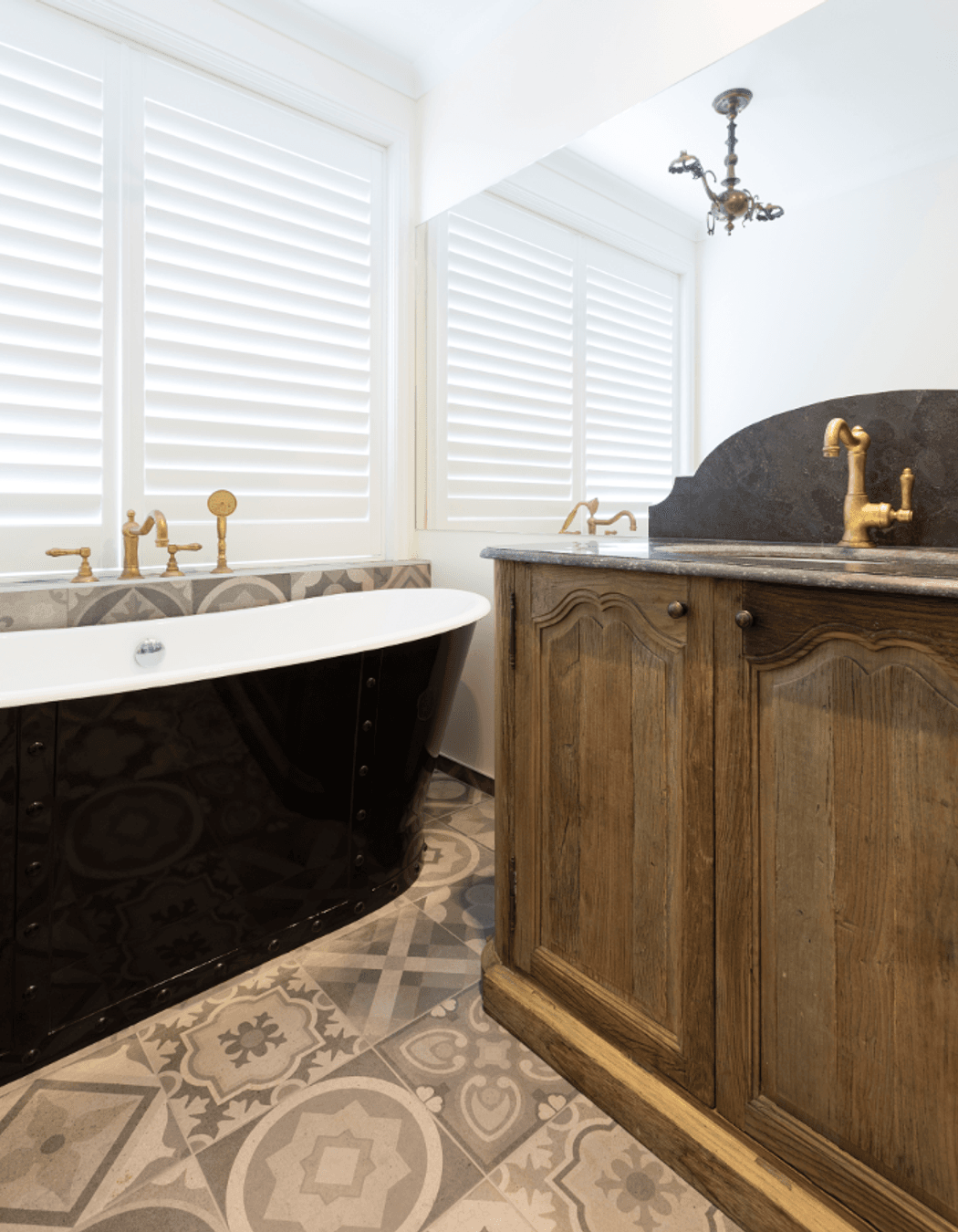 Freestanding bath with a vintage oak vanity and custom shutters 