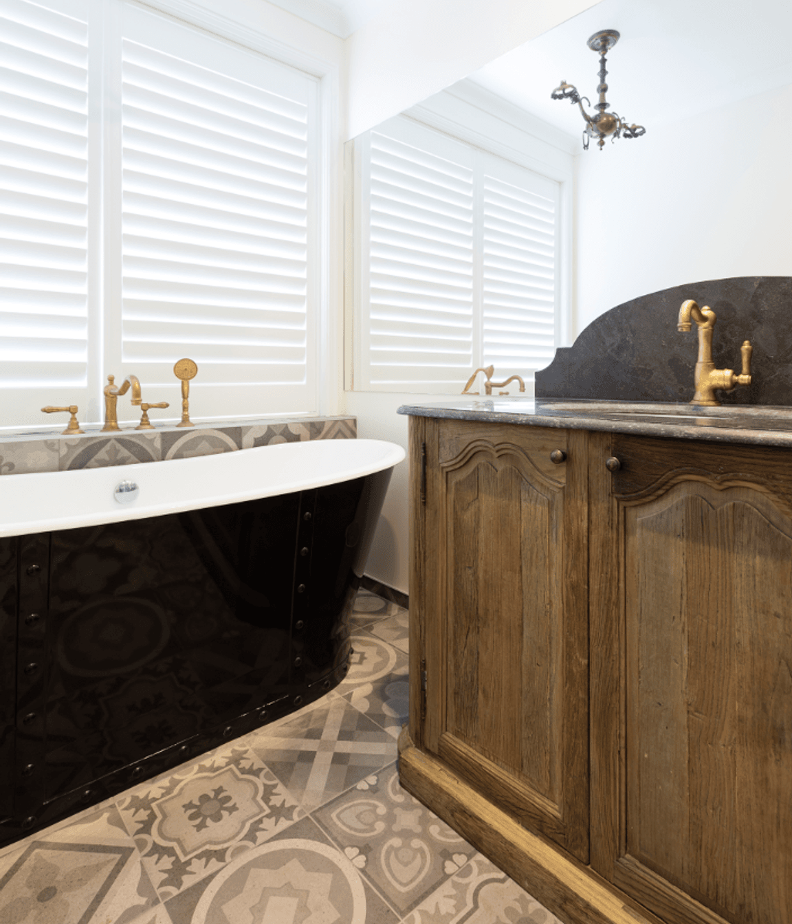 Freestanding bath with a vintage oak vanity and custom shutters 