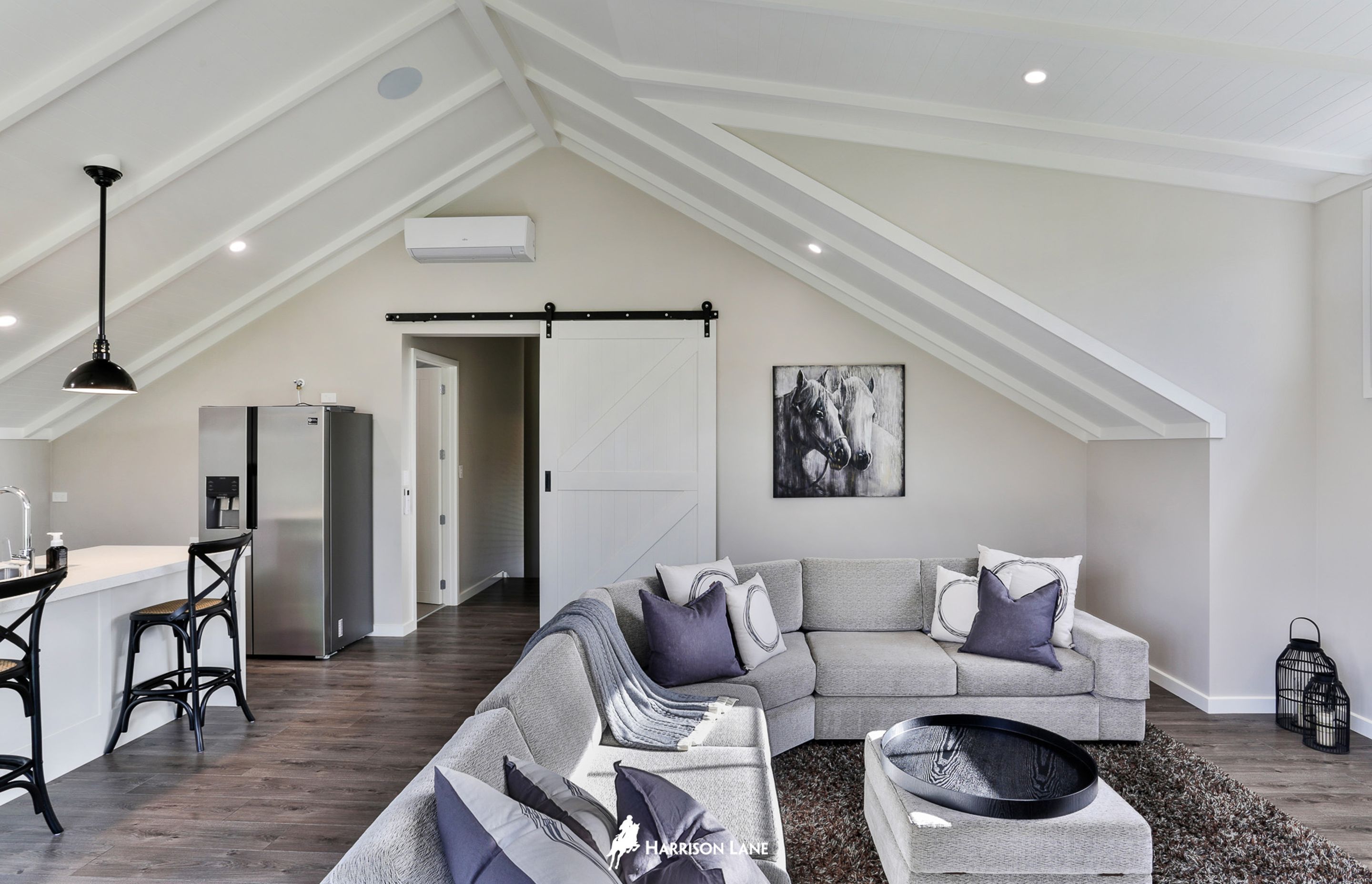 The lounge features a sliding barn door and a neutral colour palette,