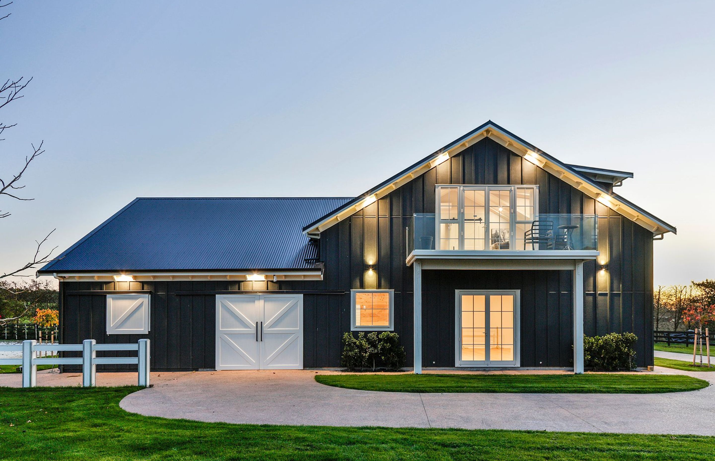 Front elevation of Goodwood Barn lit up at night.