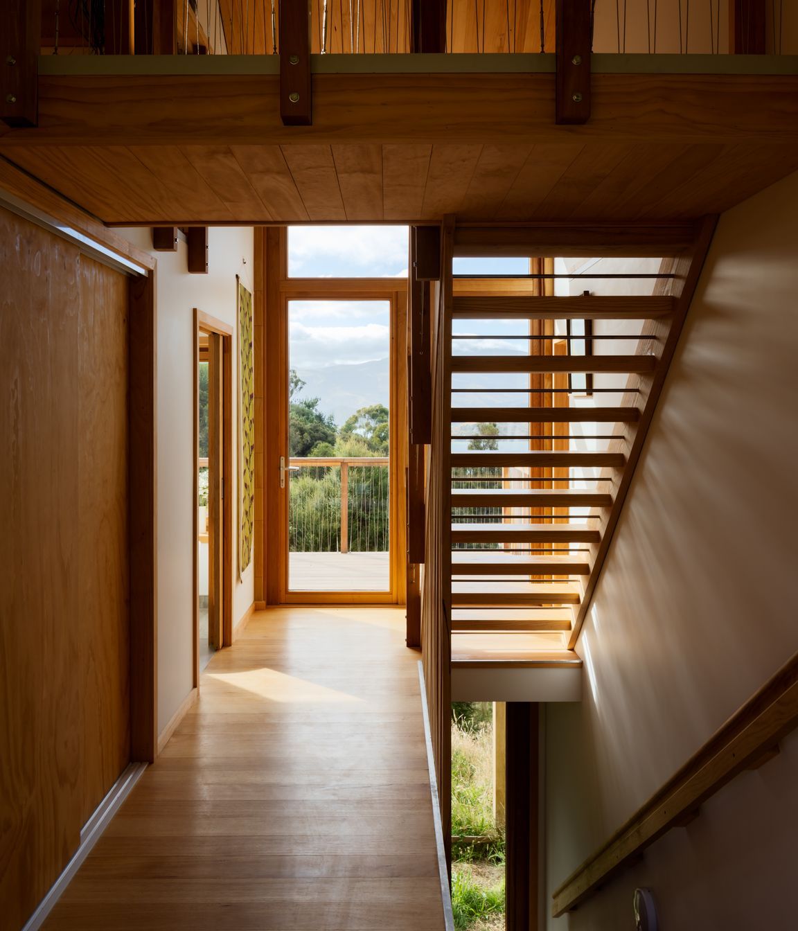 The timber staircase to the mezzanine adds to the house's overall sense of openness.