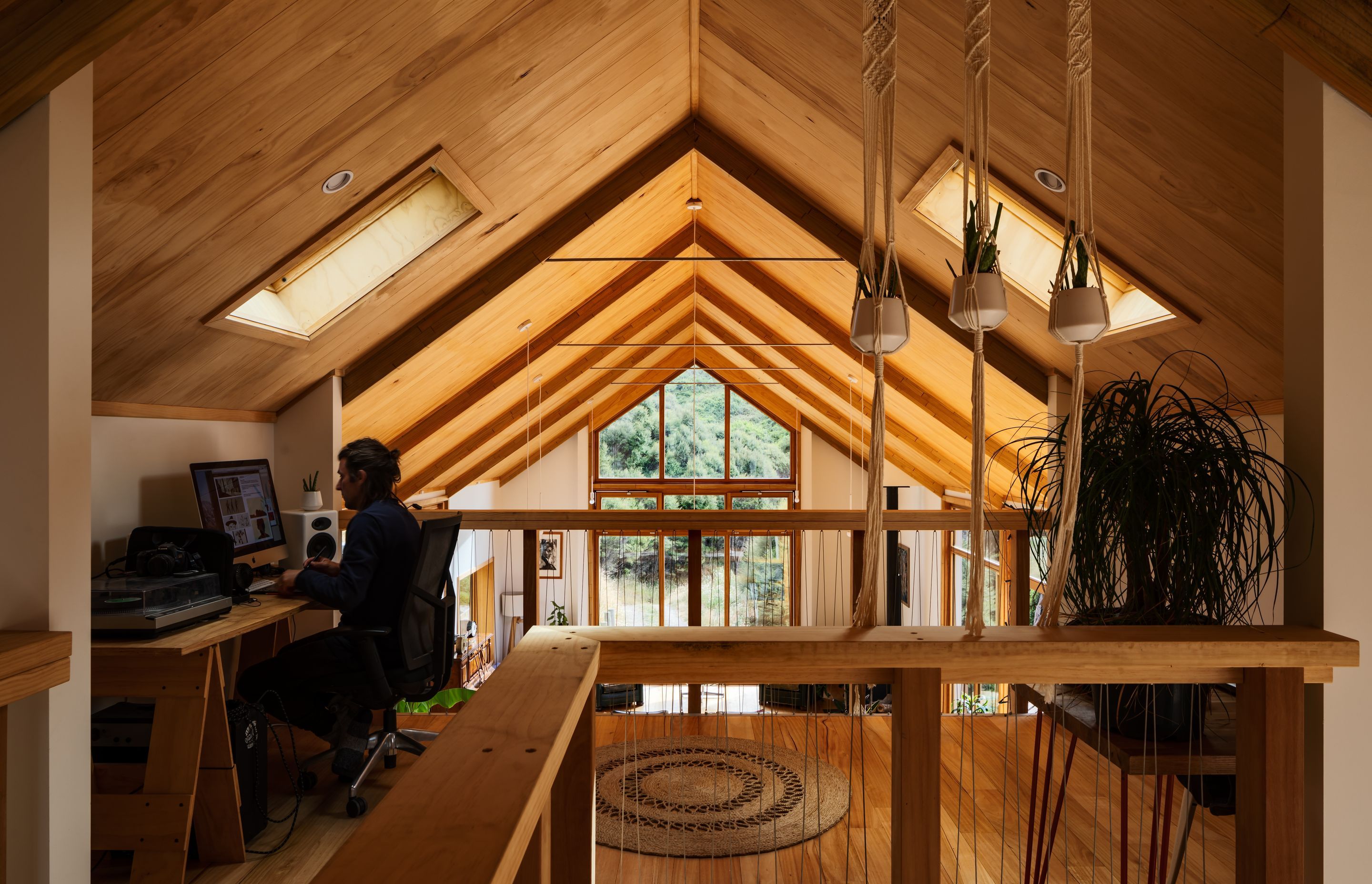 The mezzanine space is designed for study and play, drawing in light through openable skylights and the full-height gable window at the other end.
