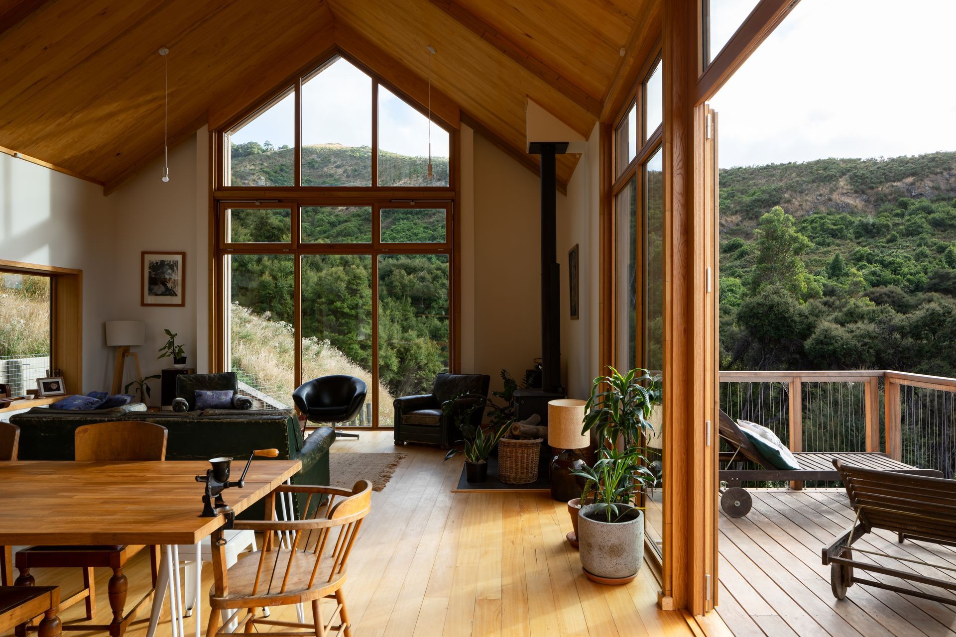 A cathedral-like gabled window draws light into the interior and frames the neighbouring bush-clad hill.