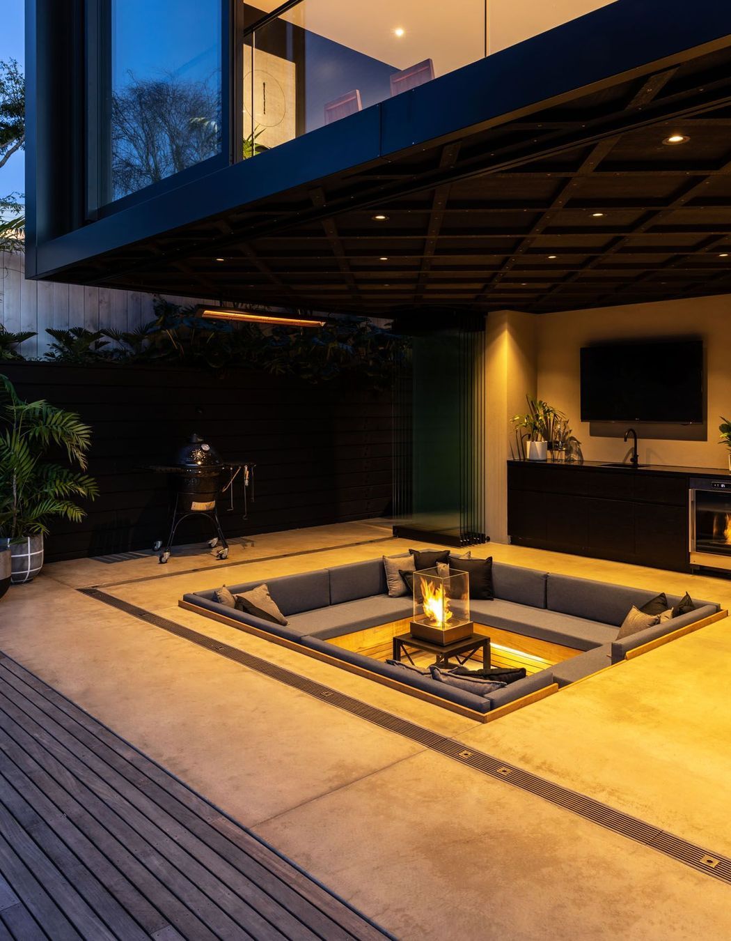 A coloured concrete floor, along with a neutral plaster finish on the walls offsets the cedar cladding.