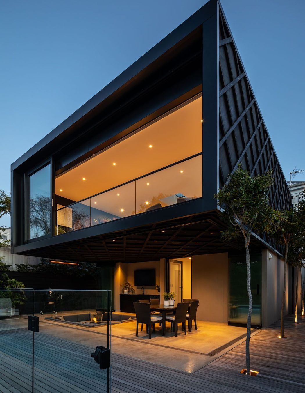 Dark stained Western Red Cedar cladding with criss-cross detailing demarcates the new extension from the original villa.