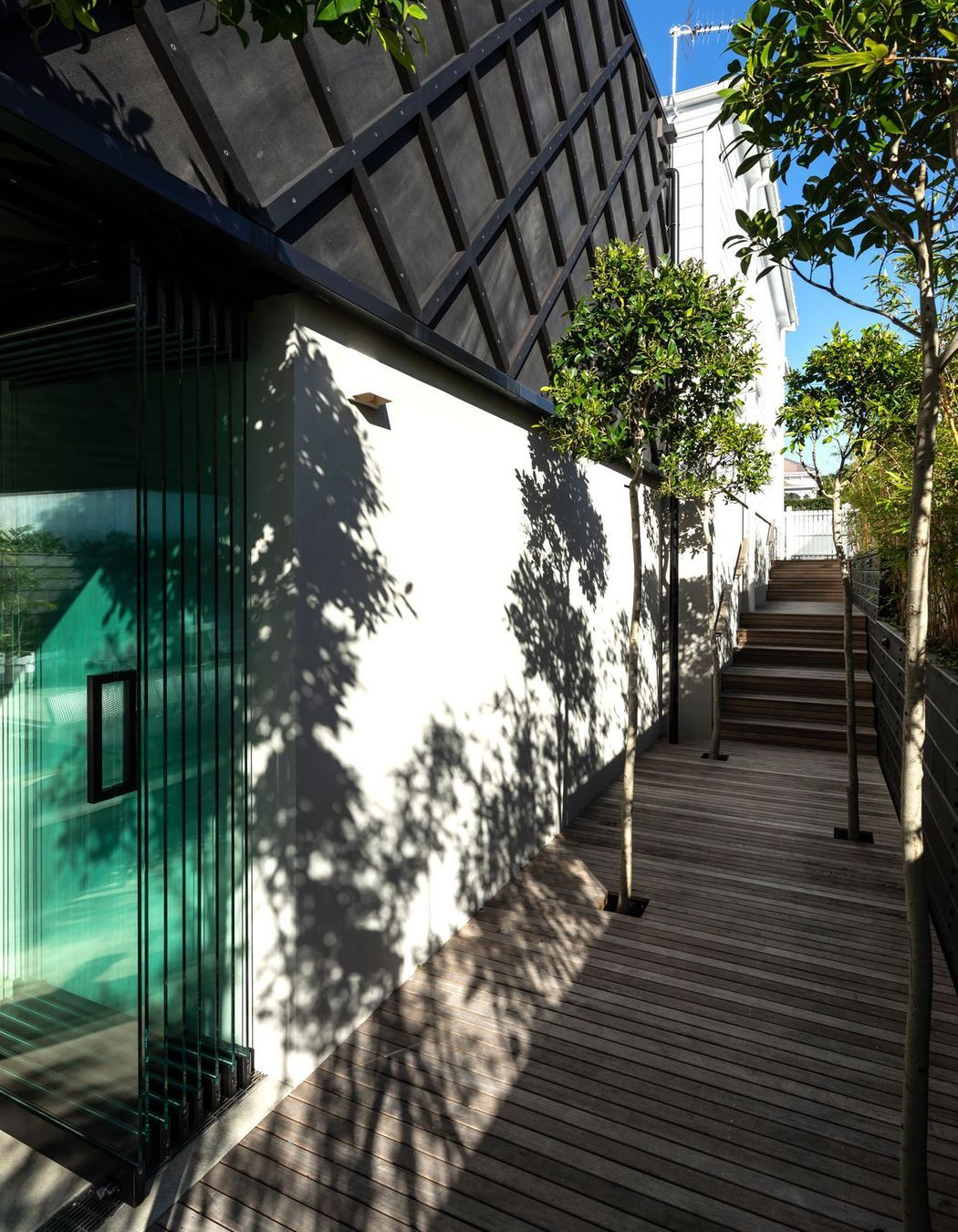 The side access from the street shows how the architects worked with the naturally sloping site to create two full levels.