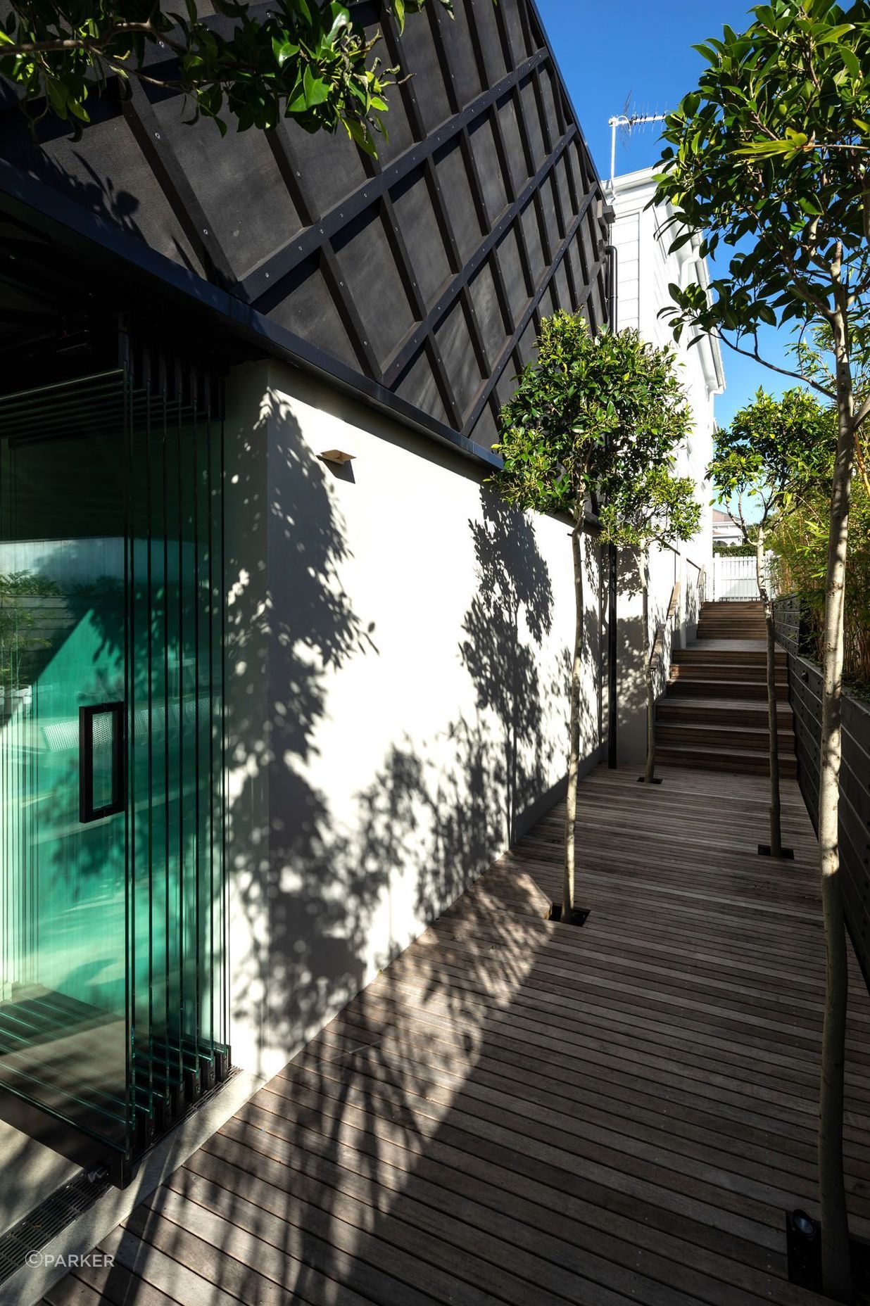 The side access from the street shows how the architects worked with the naturally sloping site to create two full levels.