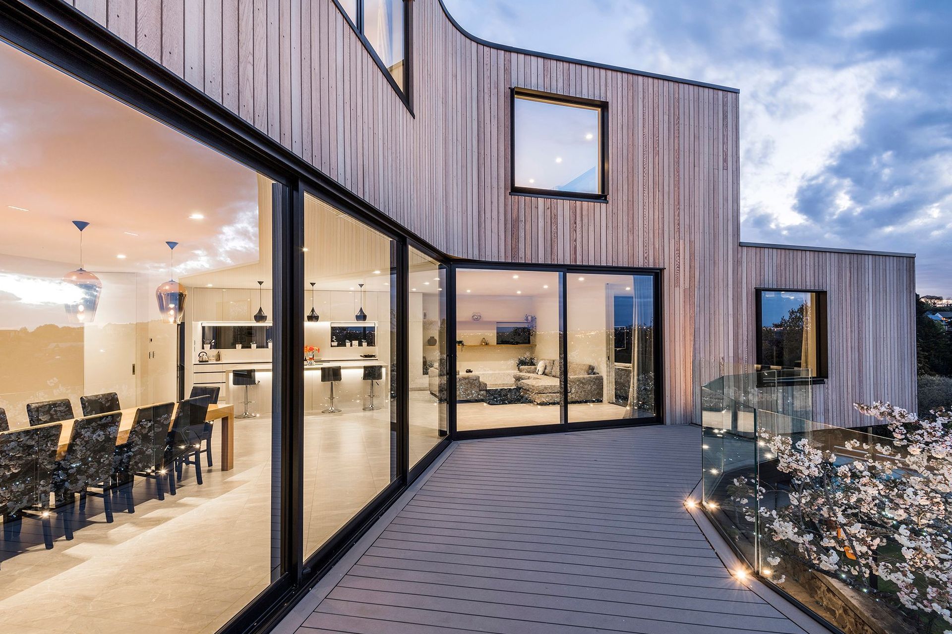A modern  light-filled living are has a kitchen and dining area in the middle, flanked by four distinct spaces for lounging.