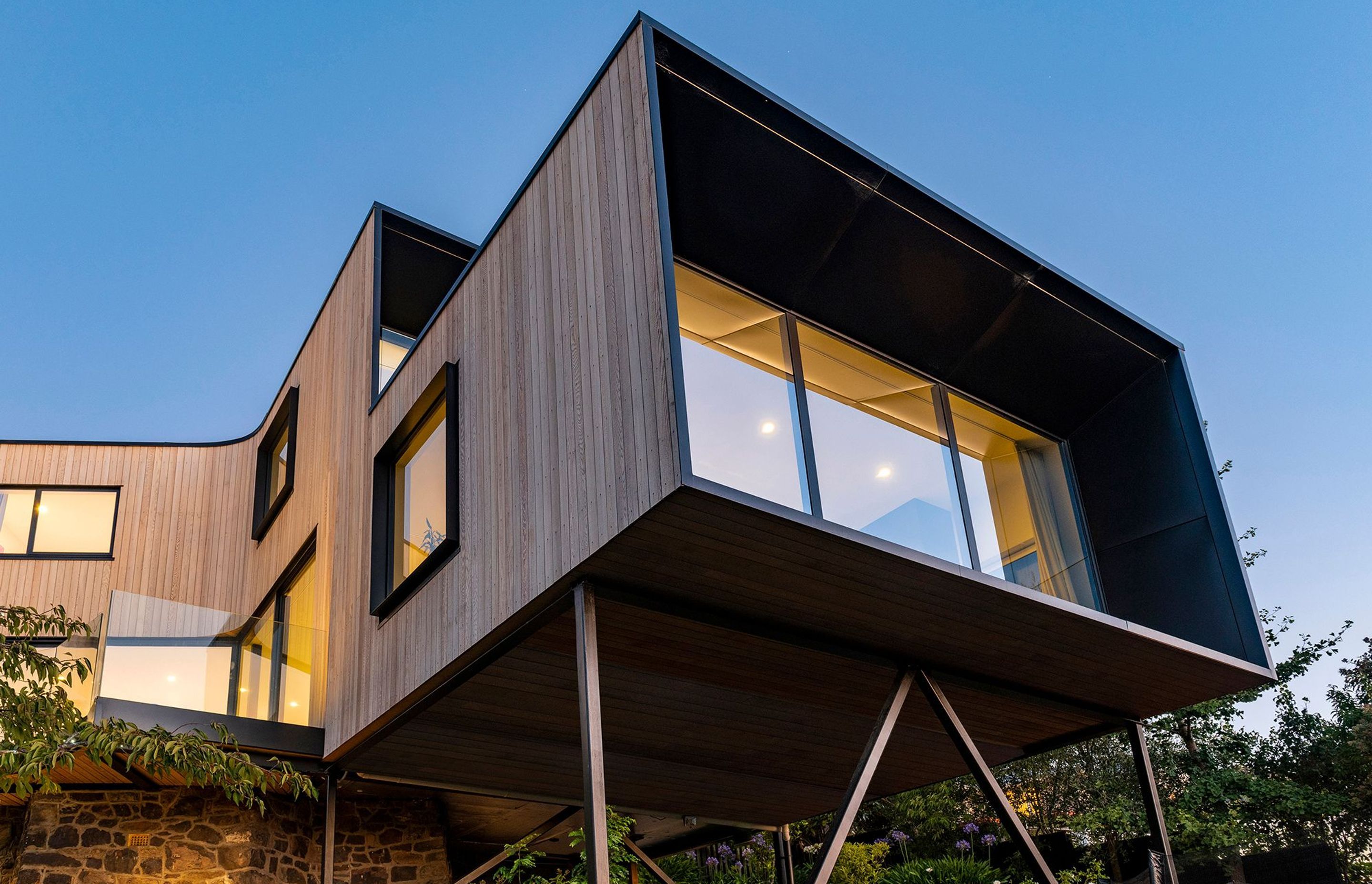 CoLab's light cedar-clad form is perched on slender steel stilts over the historic foundations of one of Christchurch's most influential architects, Samuel Hurst Seager.