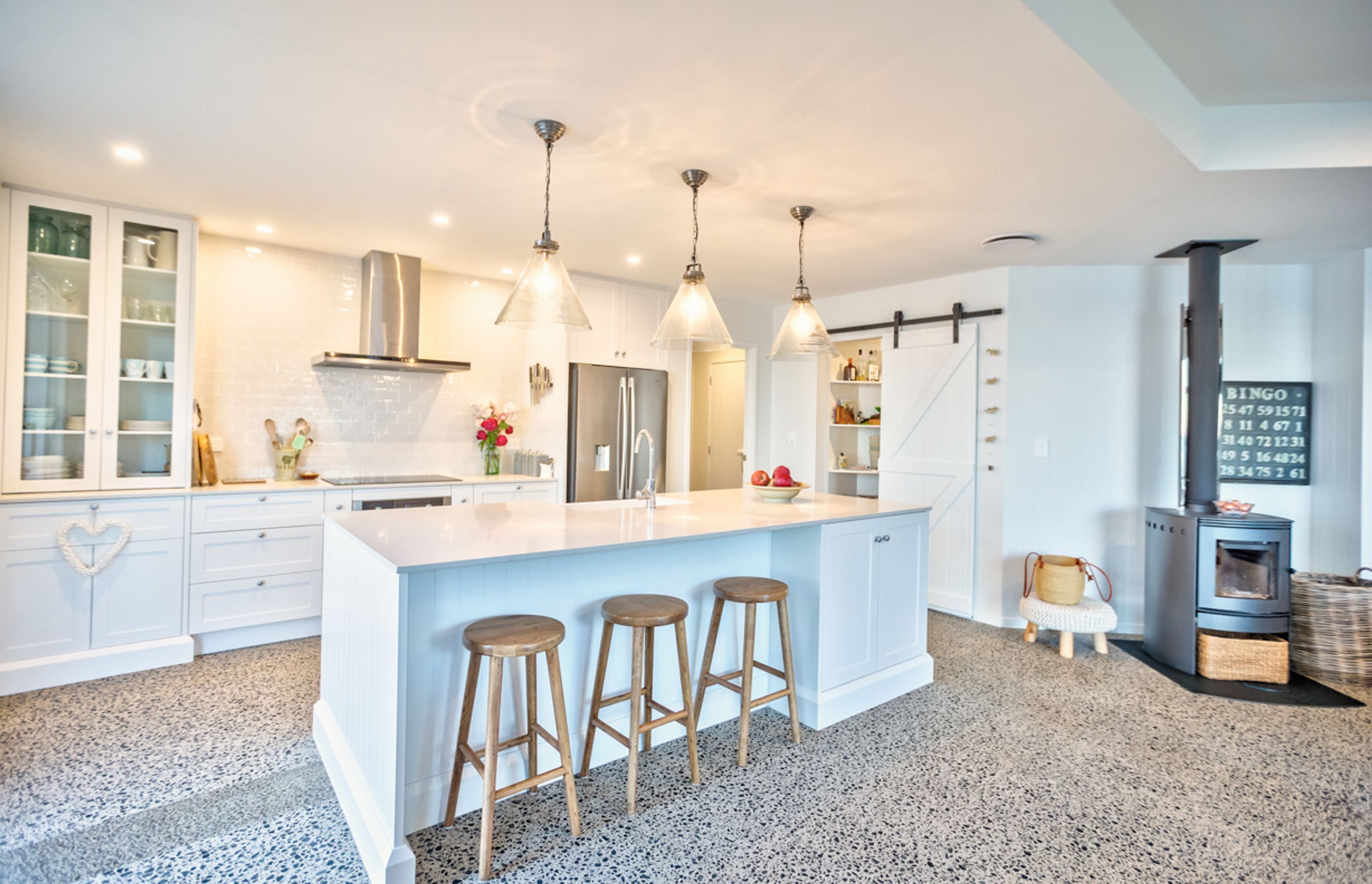 Stunning feature details include the barn door, the library and the central kitchen island. 