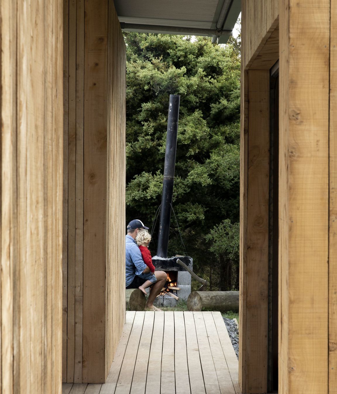 The owner, Simon Wilson, with his son building a fire in the fireplace he built himself.