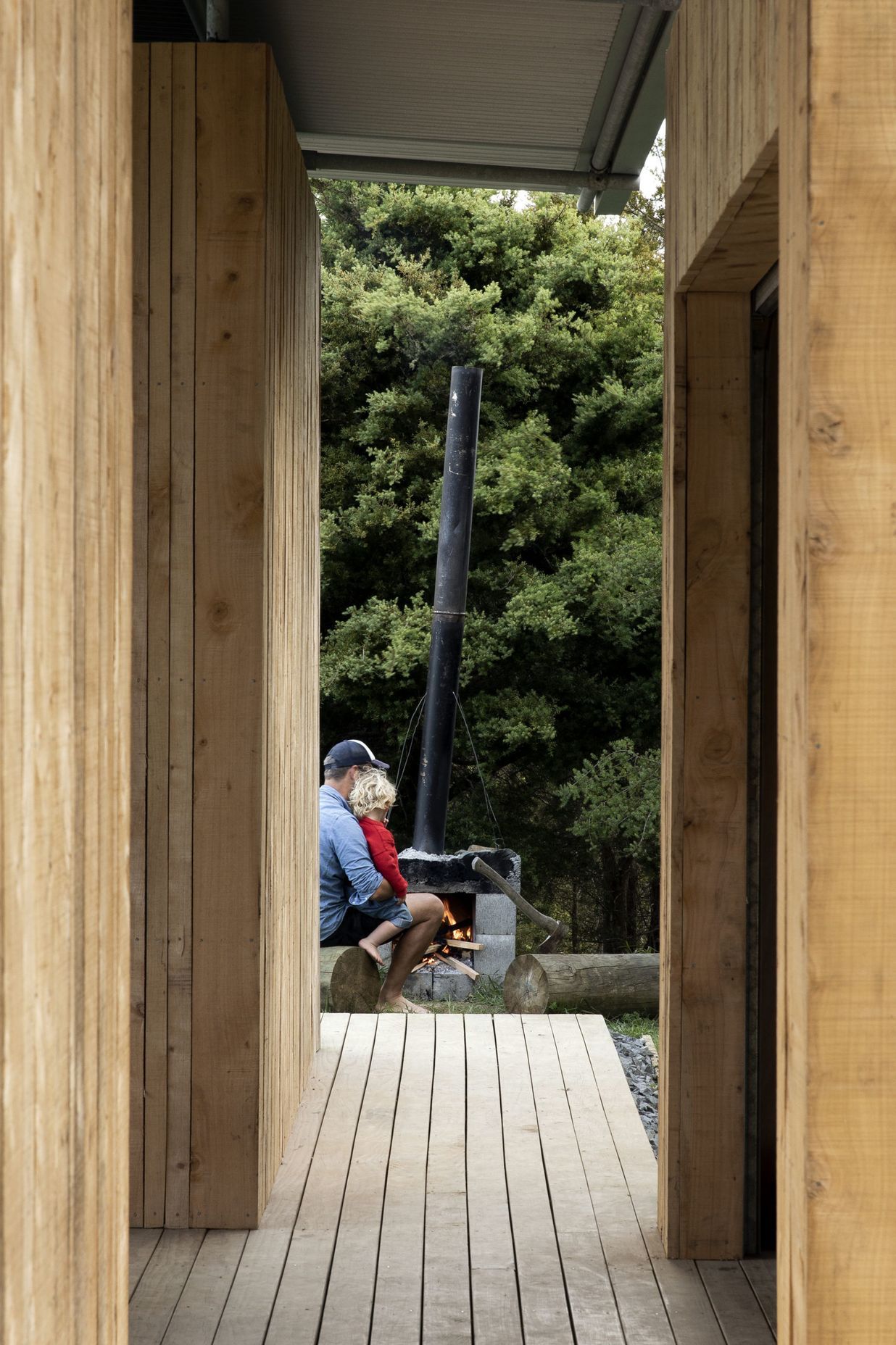 The owner, Simon Wilson, with his son building a fire in the fireplace he built himself.