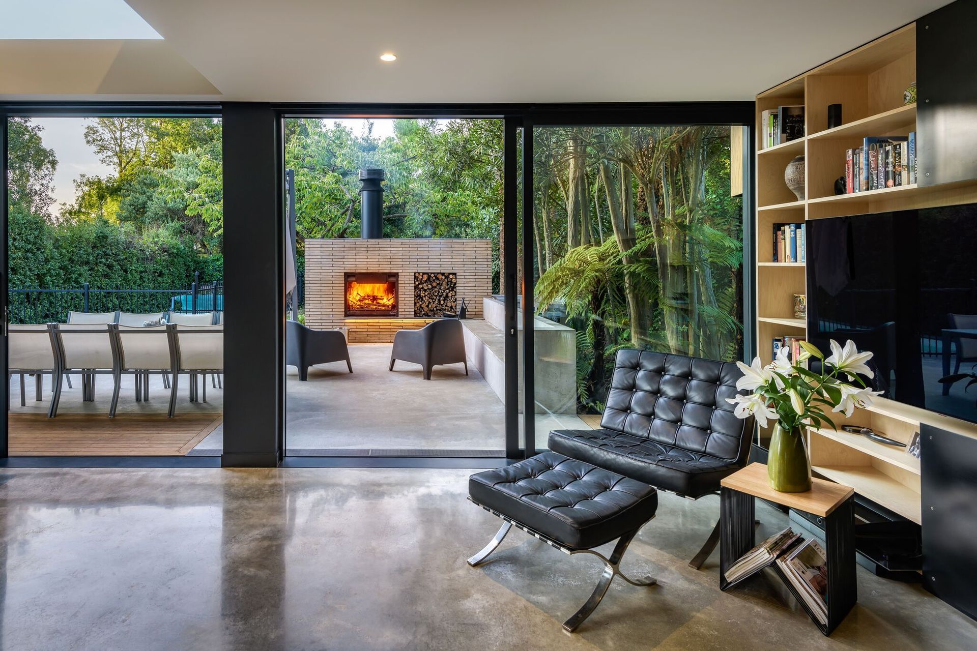 Facing north, the lounge flows out into a stunning outdoor room with a built-in fireplace/pizza oven and in-situ concrete seating.