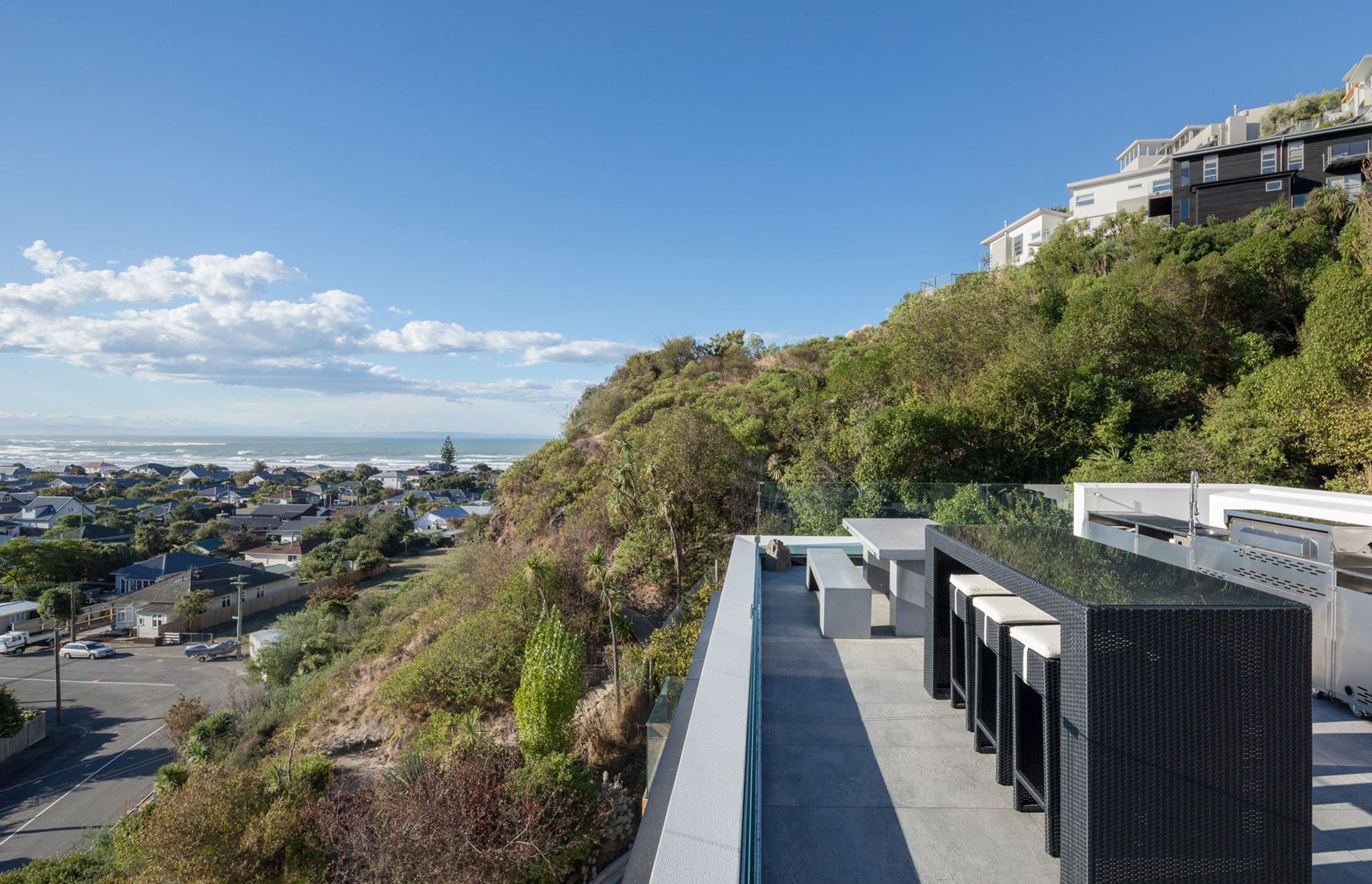 The outdoor kitchen and dining area on the roof terrace, surrounded by mostly native landscaping in its infancy, designed by Kamo Marsh.