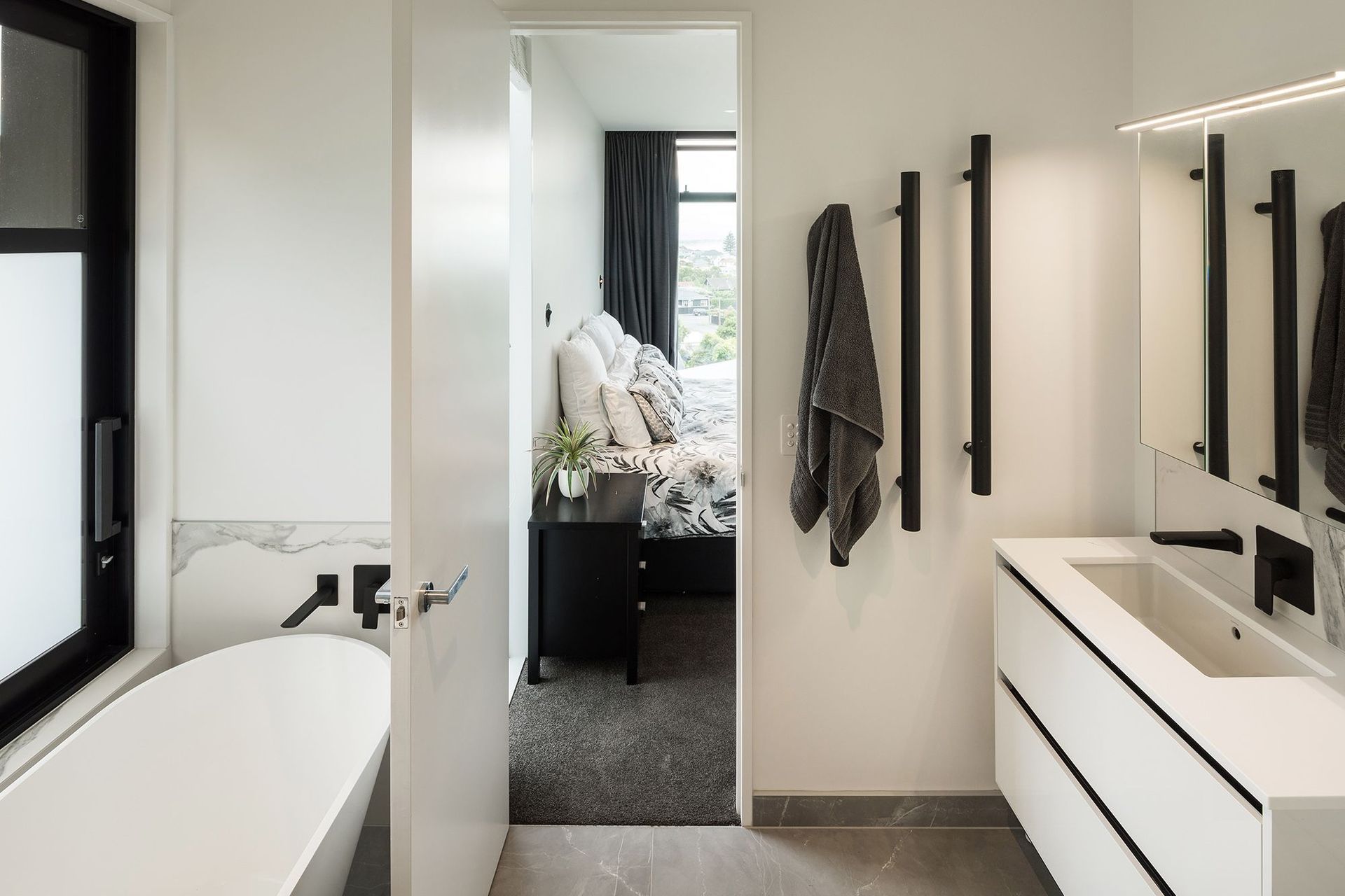 On the first floor. the ensuite bathroom from the master bedroom continues the black and white colour scheme from the living area.