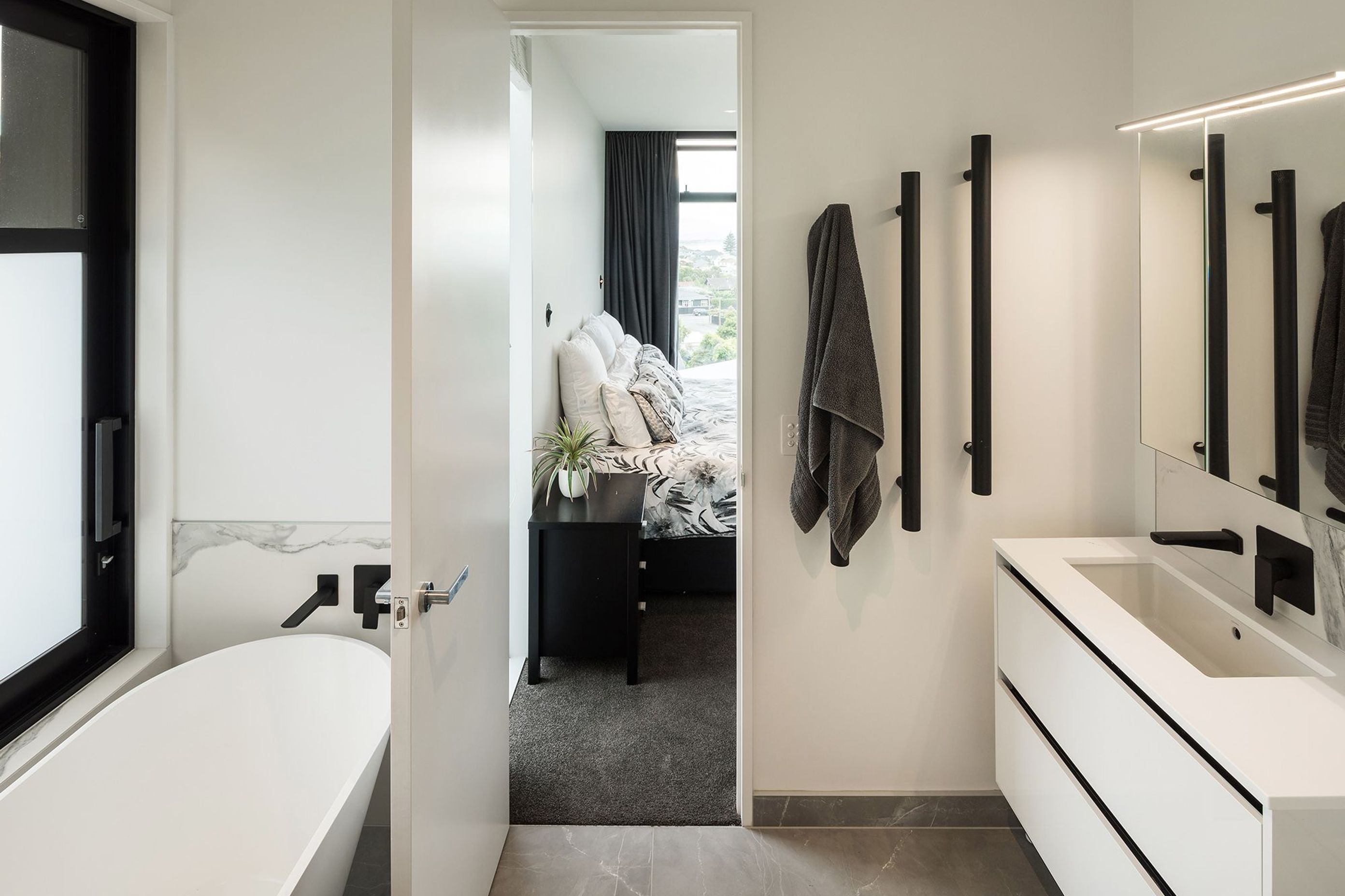 On the first floor. the ensuite bathroom from the master bedroom continues the black and white colour scheme from the living area.