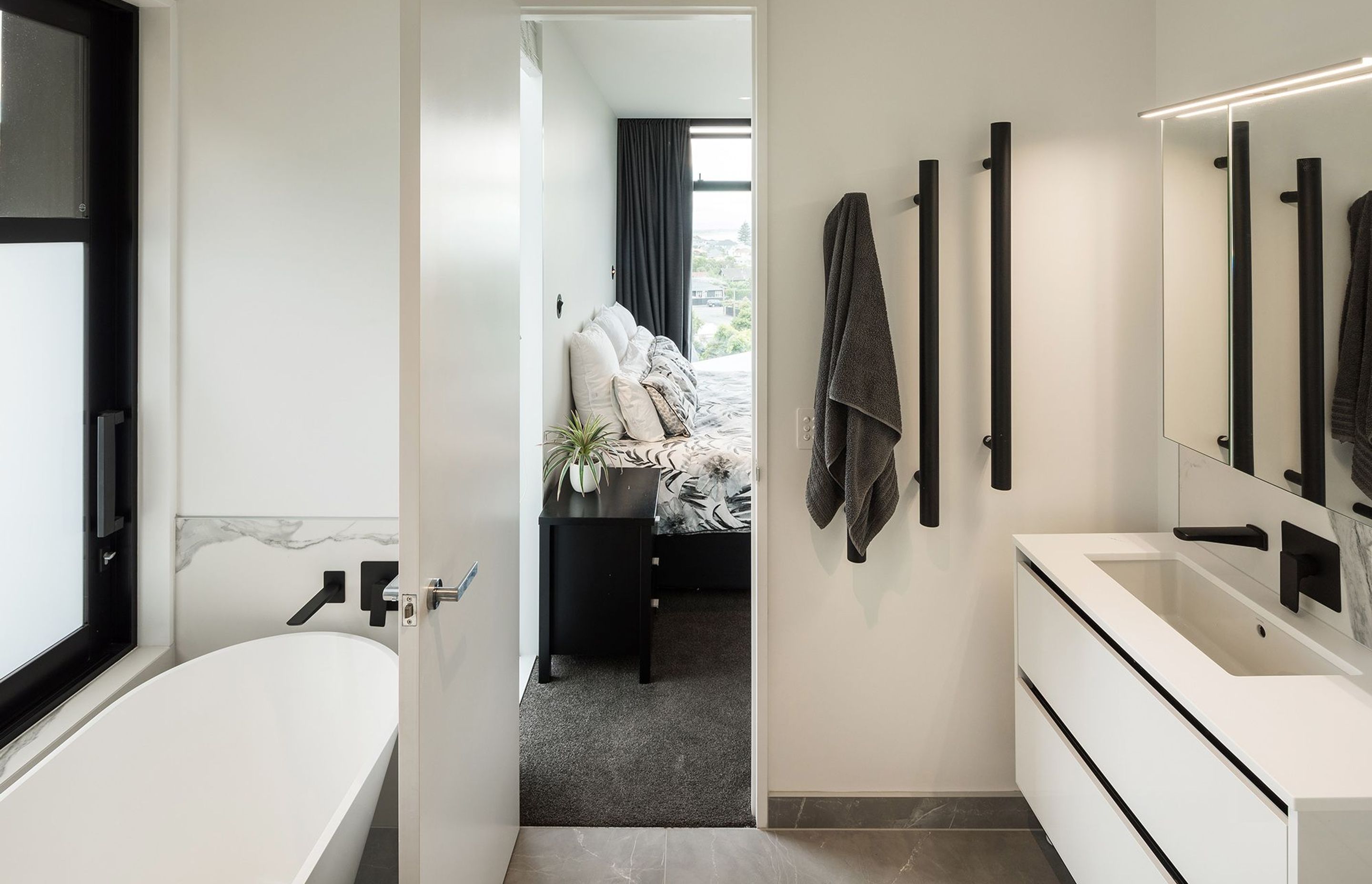 On the first floor. the ensuite bathroom from the master bedroom continues the black and white colour scheme from the living area.