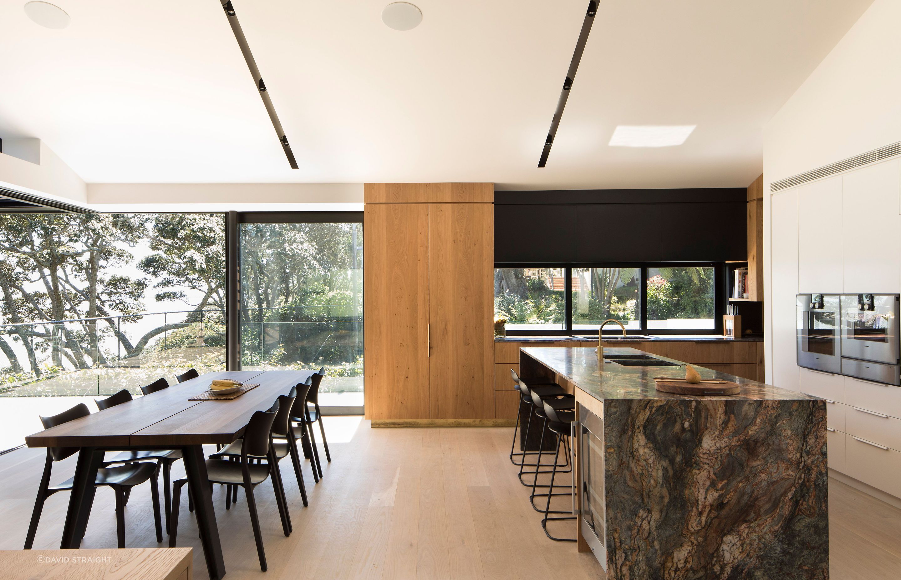 The kitchen enjoys a views of the neighbours tennis court and across the living space to the ocean.