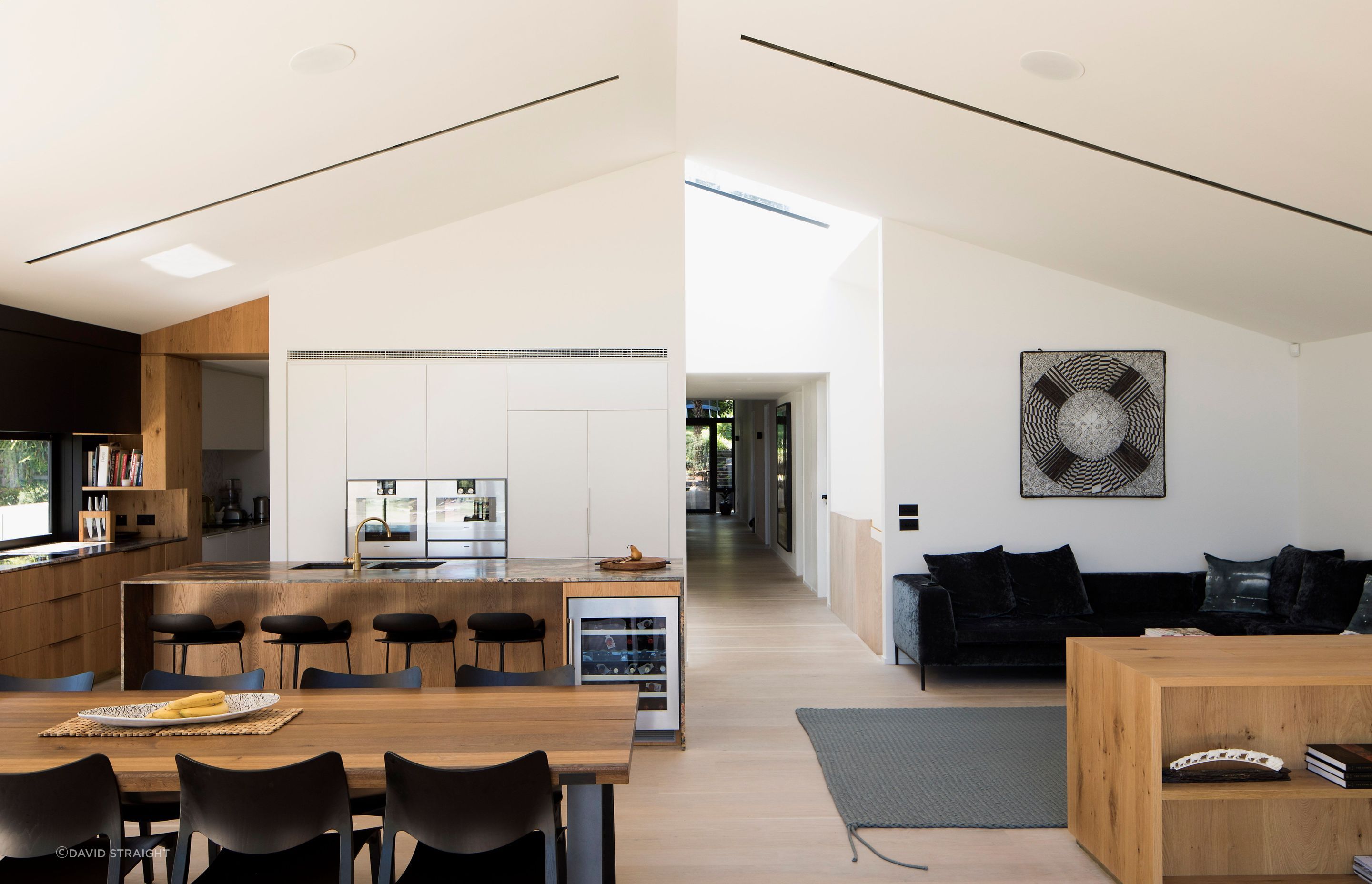 The open-plan living, dining and kitchen space leading to a scullery on the left and the central corridor just off the central axis.