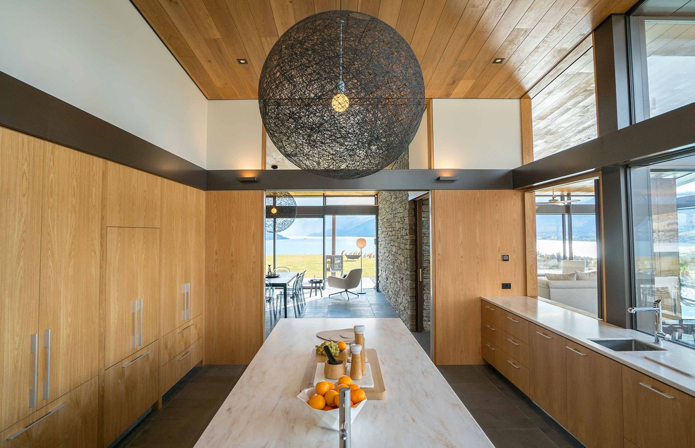 The kitchen joinery features engineered American oak, stained with coffee and natural oil, and an island with a light-coloured Corian top. Photograph: ArchiPro.