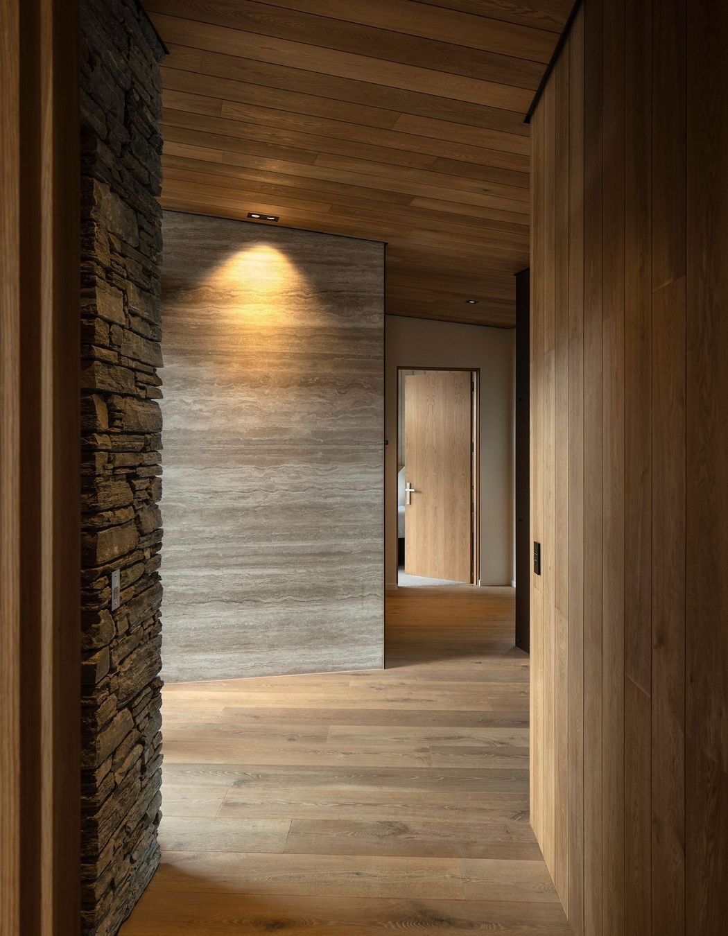 Travertine, schist and timber create a dramatic corridor. Photograph: Simon Devitt.