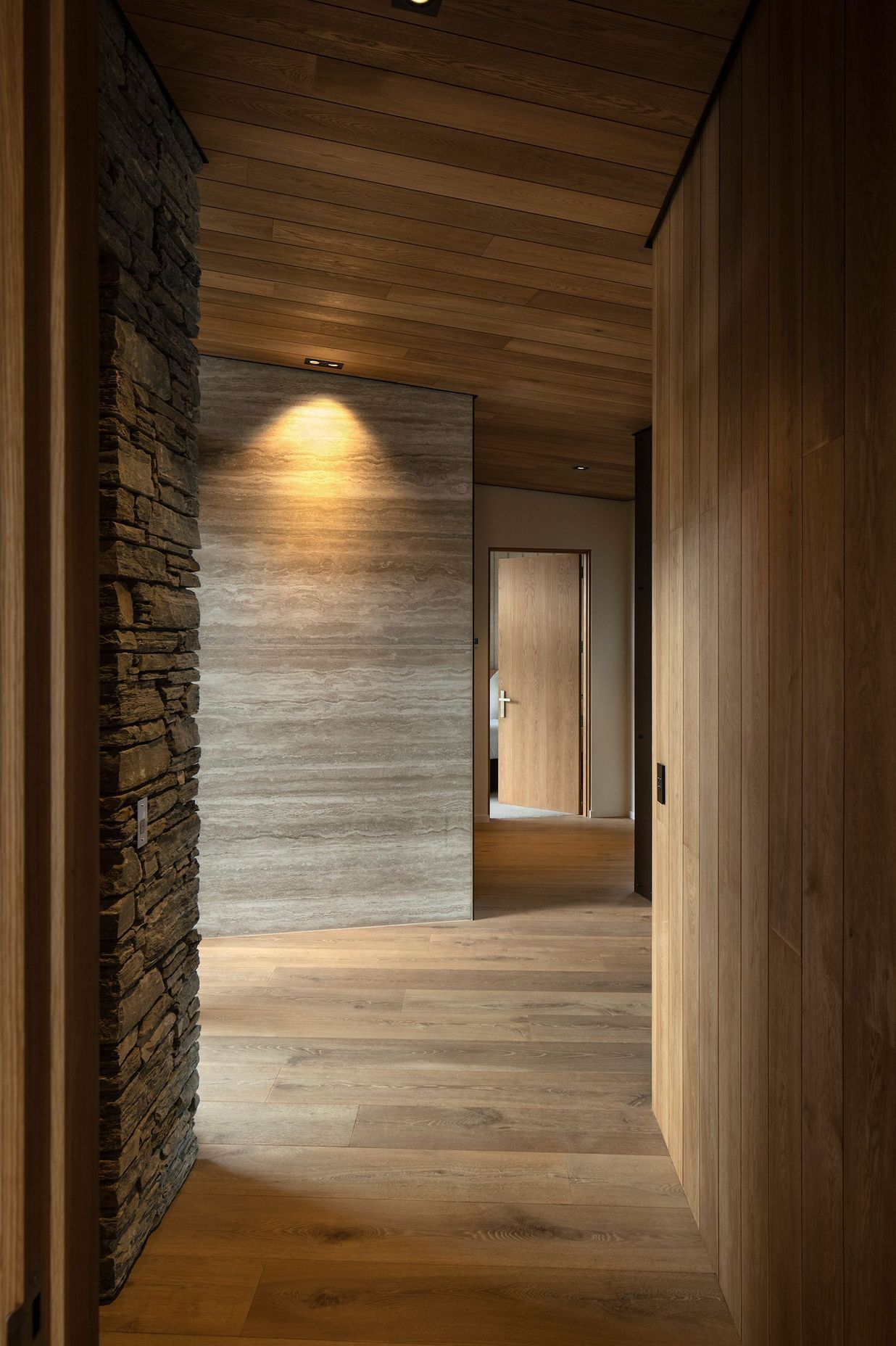 Travertine, schist and timber create a dramatic corridor. Photograph: Simon Devitt.