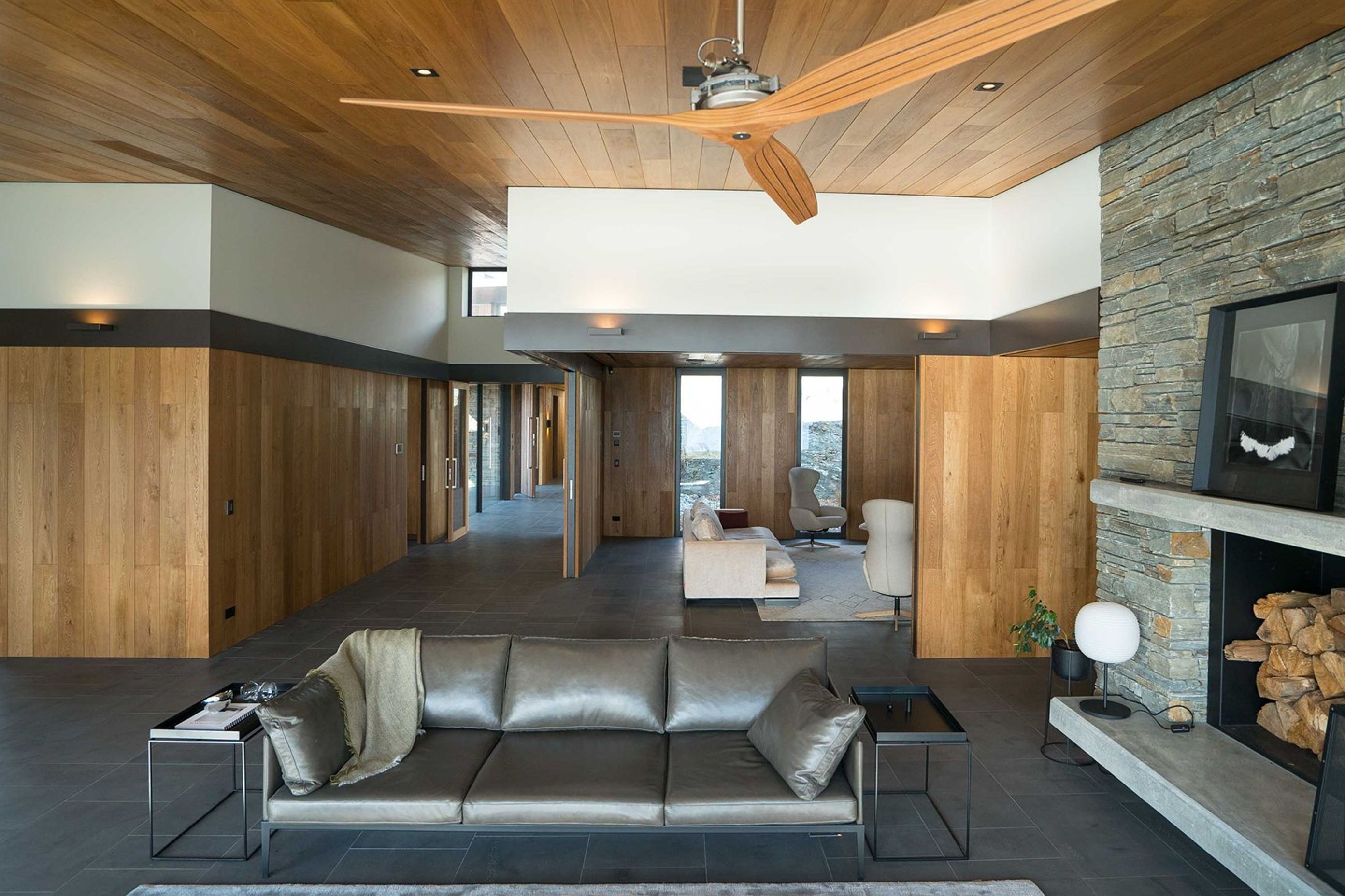 Oak-panelled walls and ceiling adds warmth to the Timaru bluestone flooring and Alexandra schist feature wall. Photograph: ArchiPro.